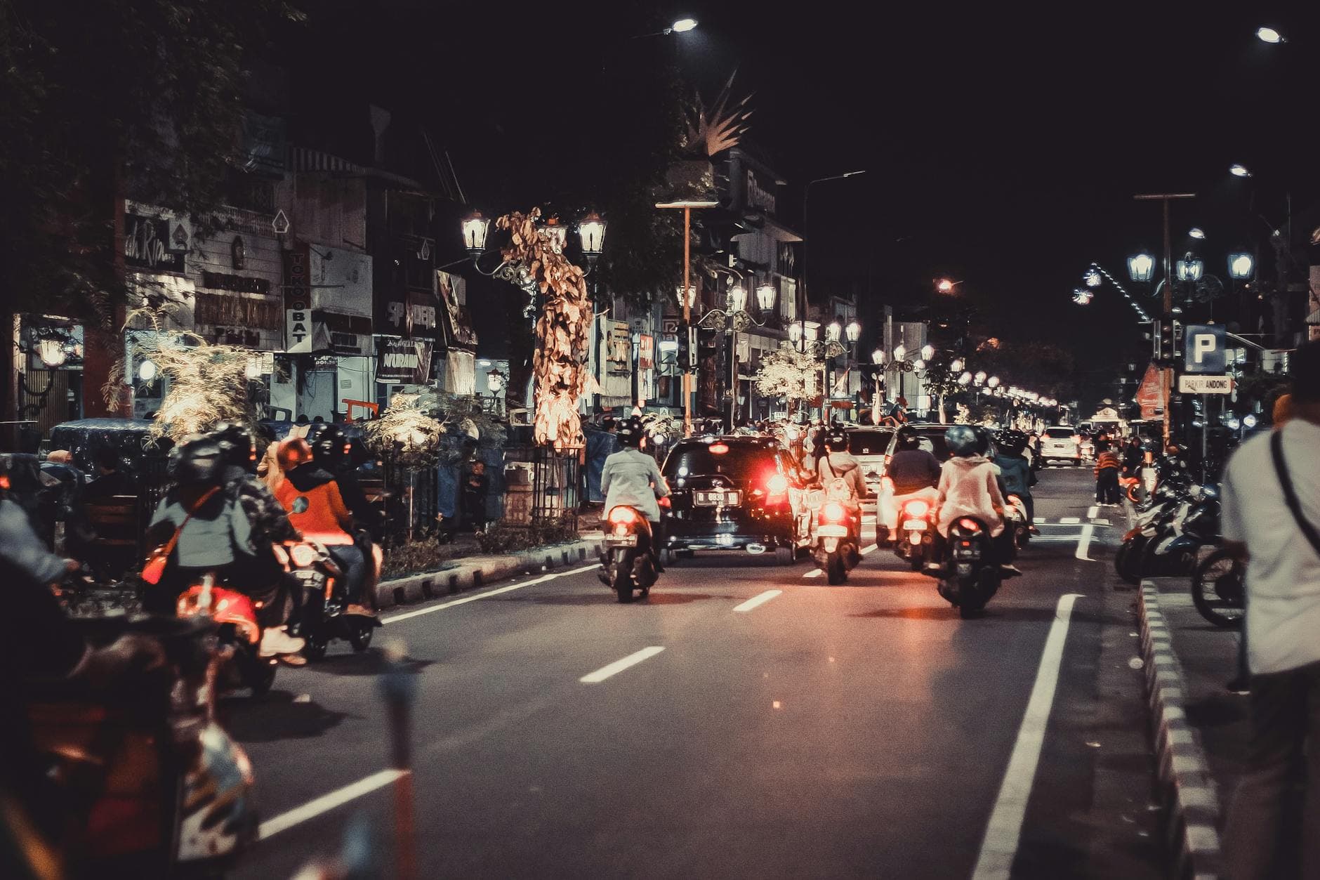 Lively night street with cars and motorbikes. Urban life and vibrant lights capture the essence of downtown energy.