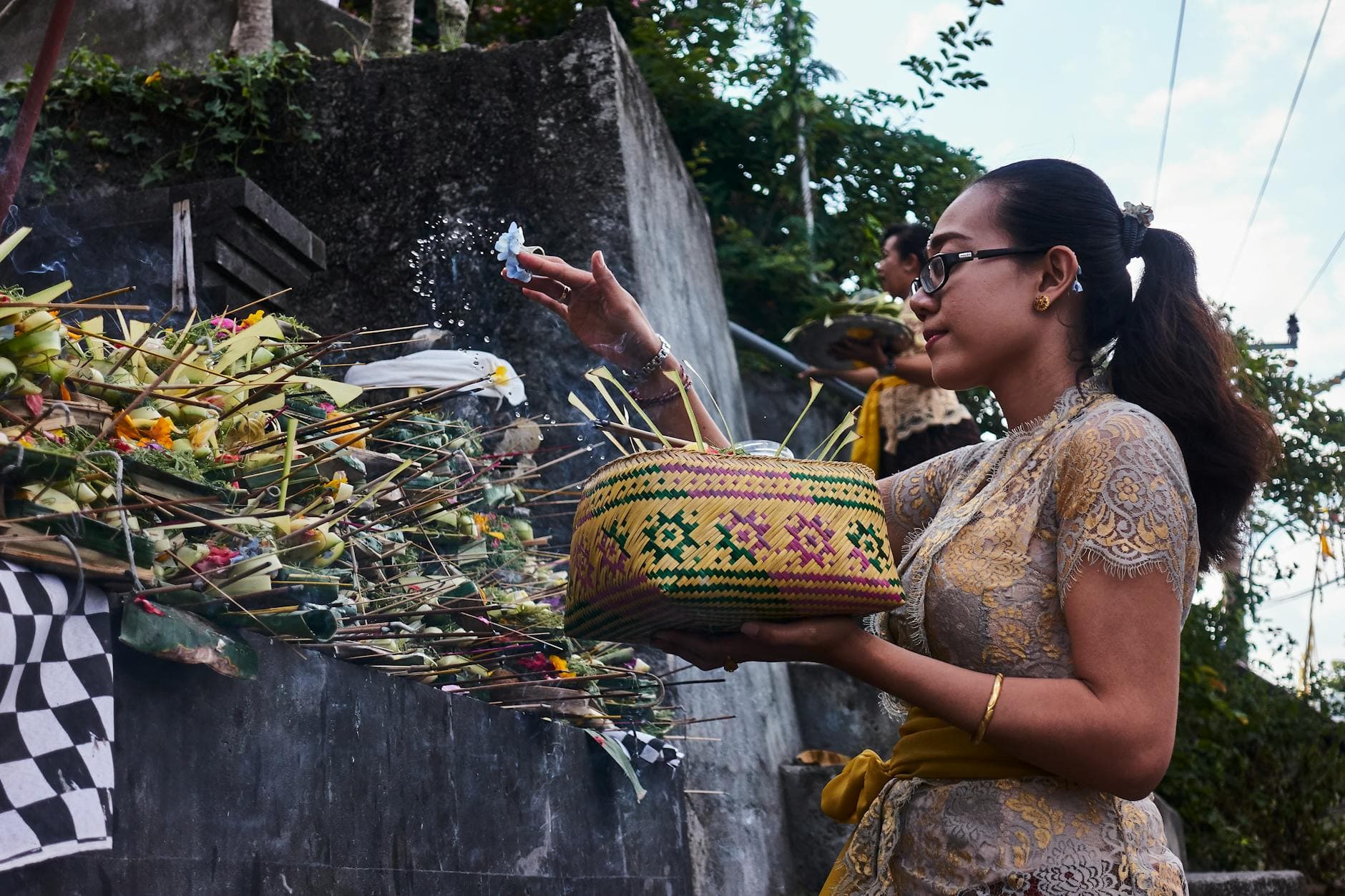 A woman performs a traditional Hindu offering ceremony in Bali, Indonesia.