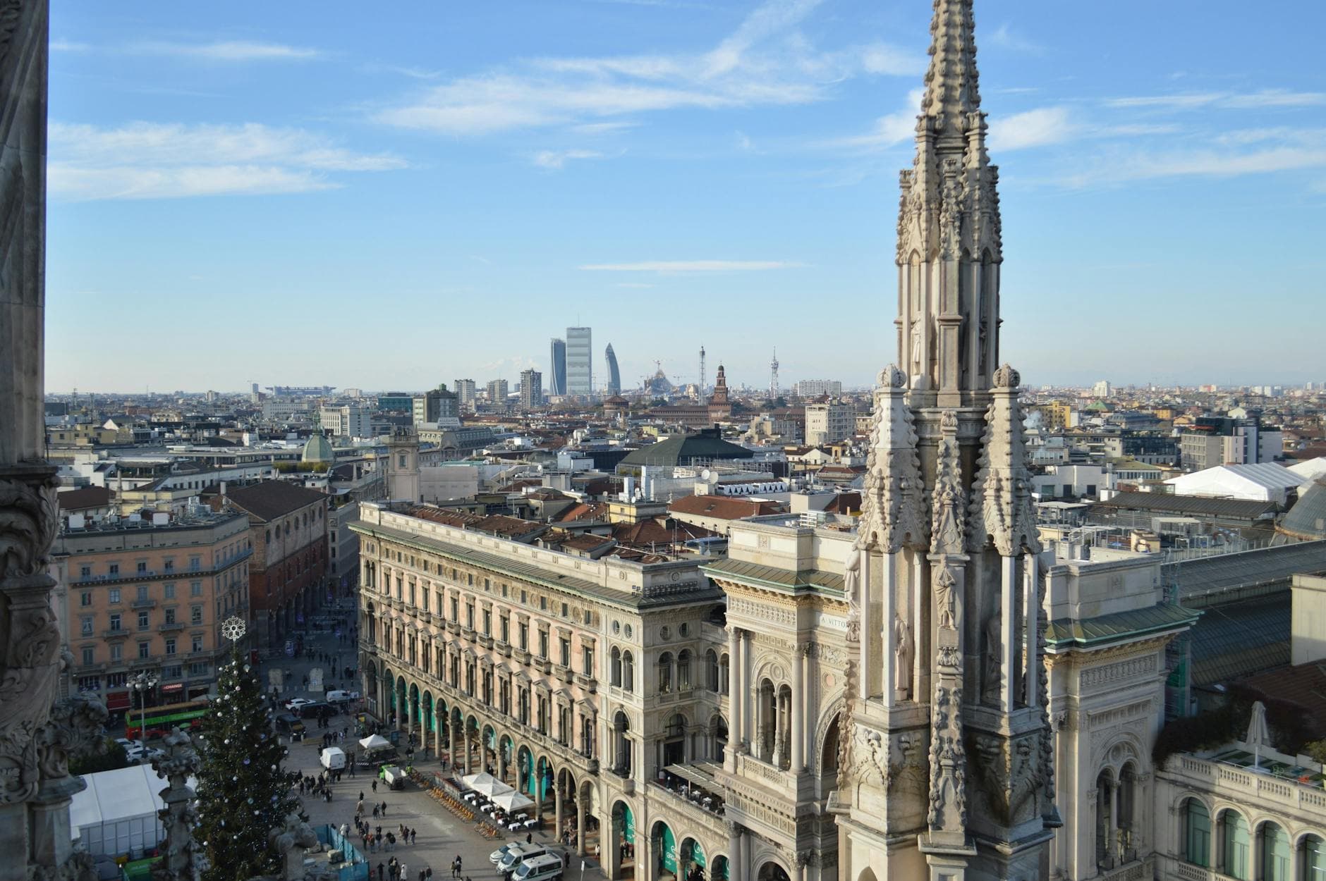 Stunning aerial view of Milan's skyline with the iconic Duomo spire in the foreground.
