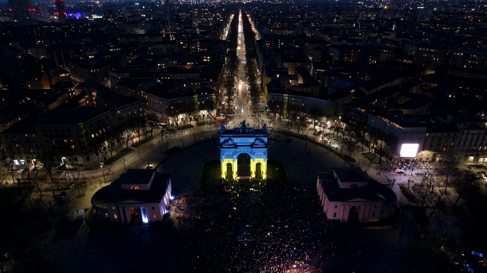 A breathtaking aerial night view of Arco della Pace in Milan, Italy, beautifully illuminated.