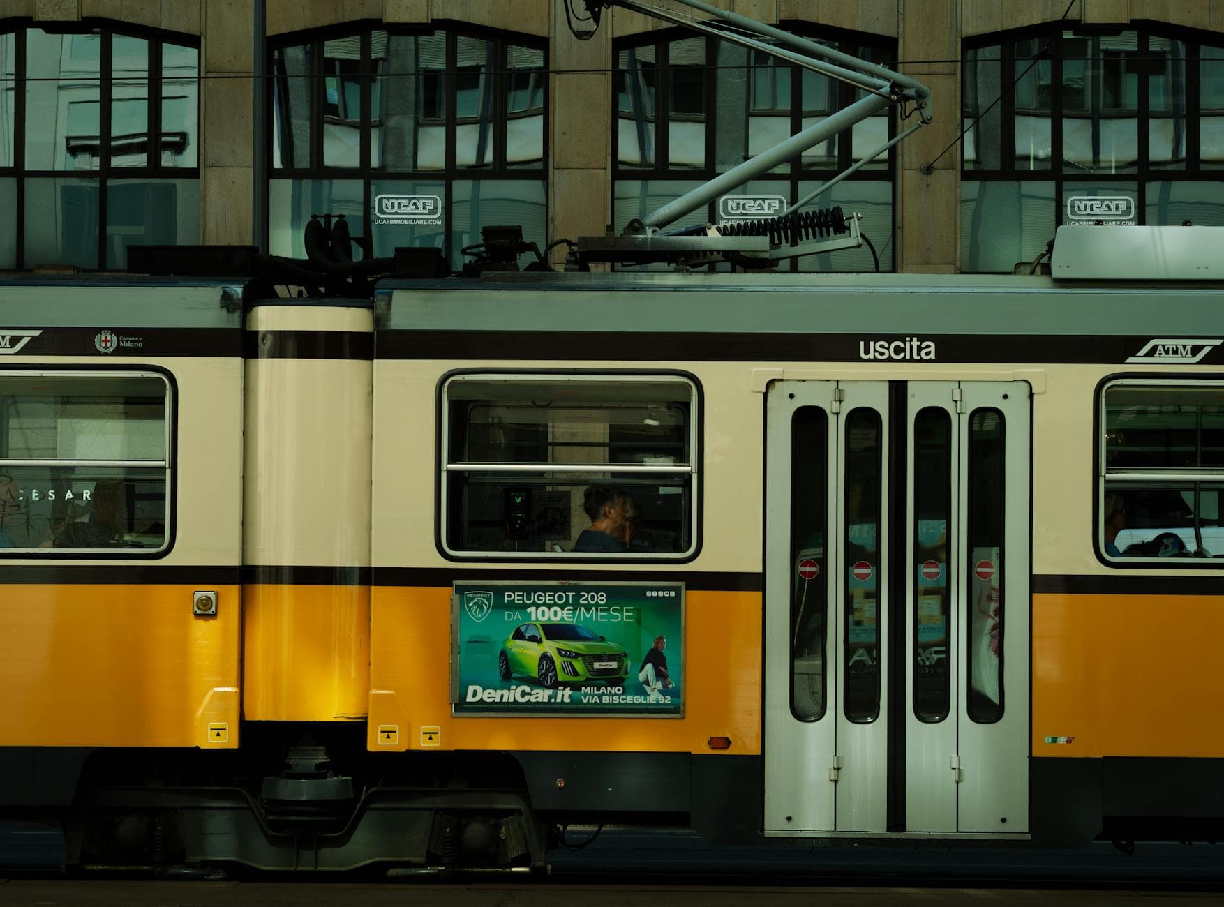 Vintage yellow tram in Milan, Lombardy, Italy. Iconic urban transportation captured in a city setting.