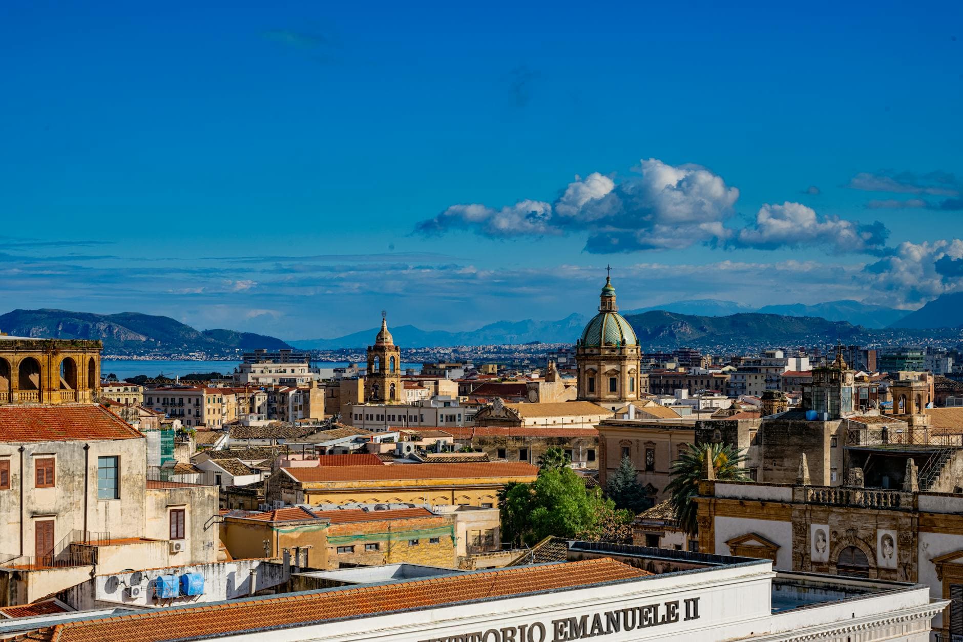 Discover the vibrant skyline of Palermo, Sicily capturing historic architecture beneath a bright blue sky.
