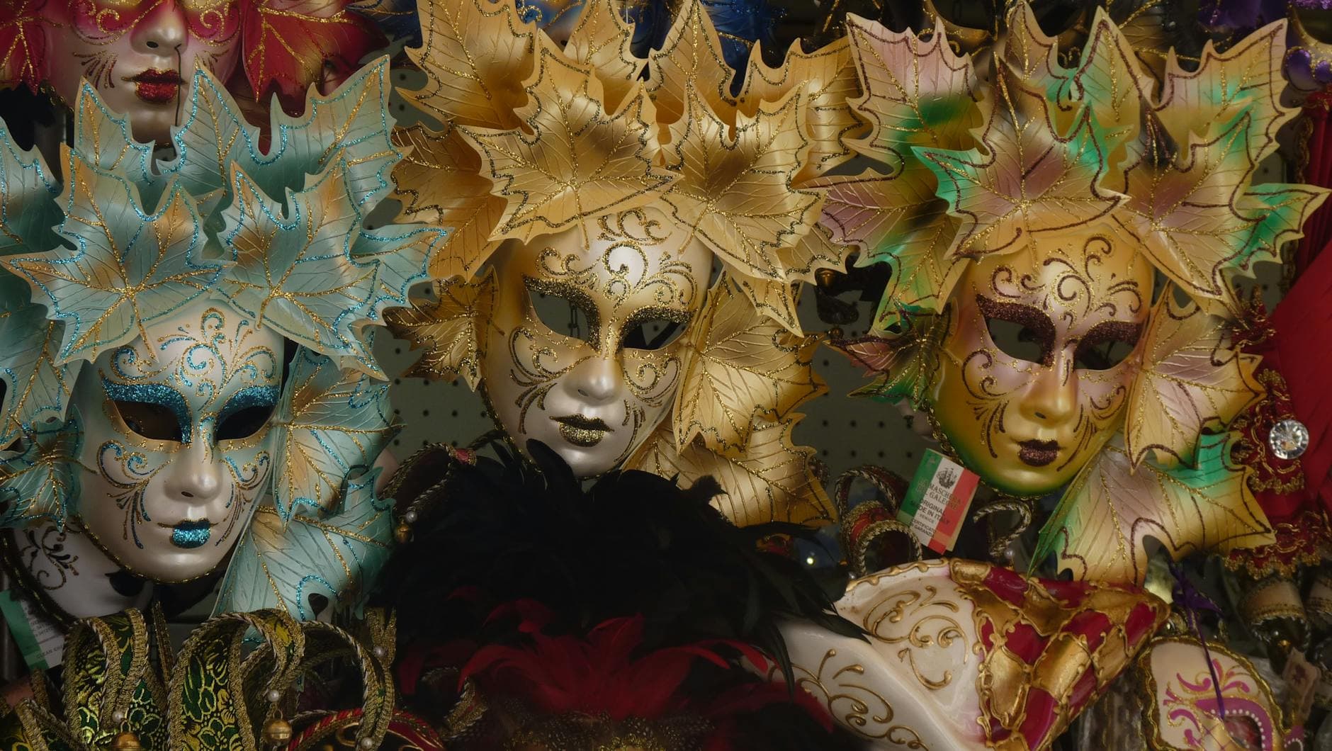 Vibrant Venetian masks with intricate designs exhibited at Venice Carnival, Italy.