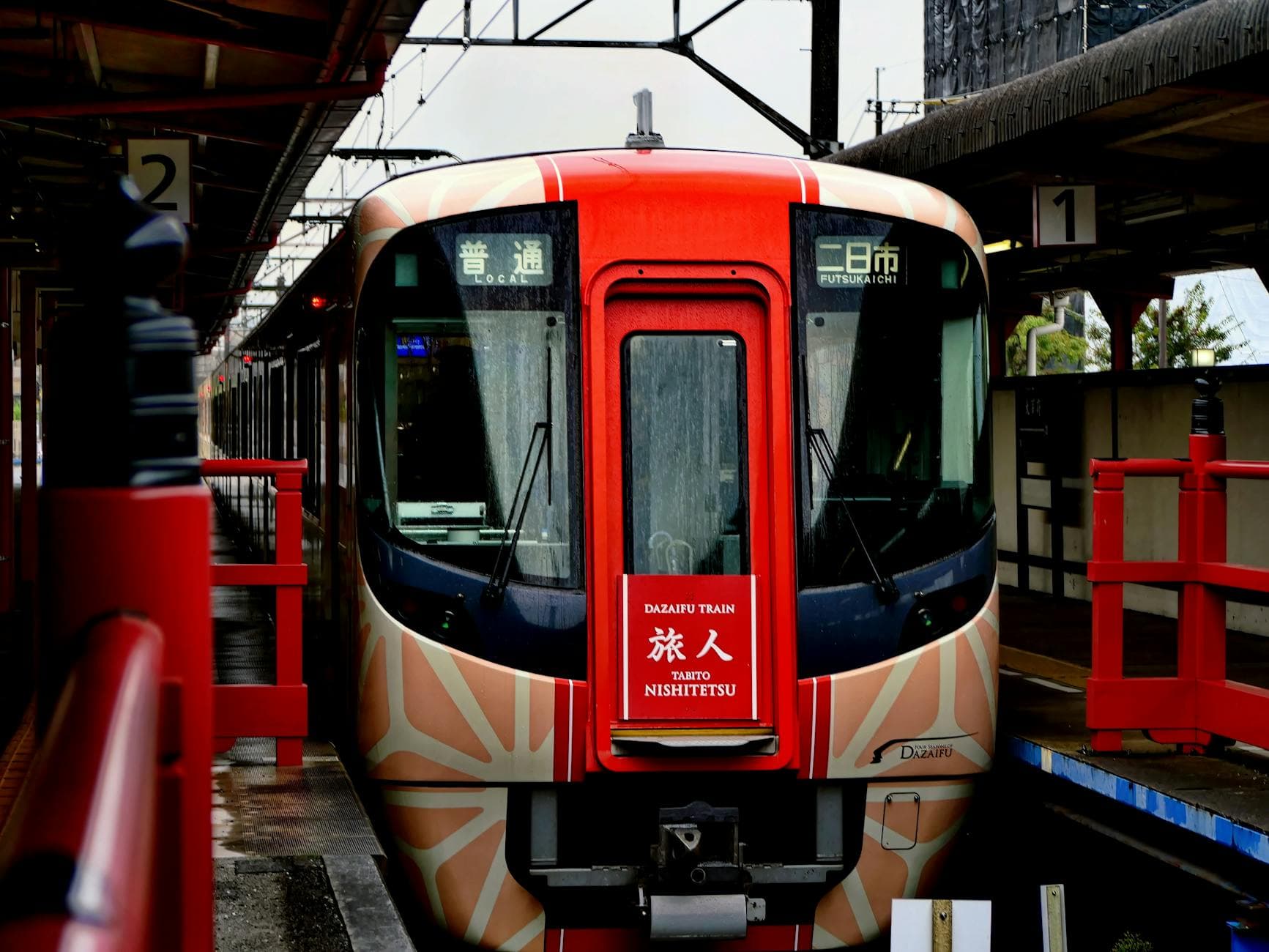 Colorful Dazaifu train at Fukuoka terminal, showcasing Japanese public transit.