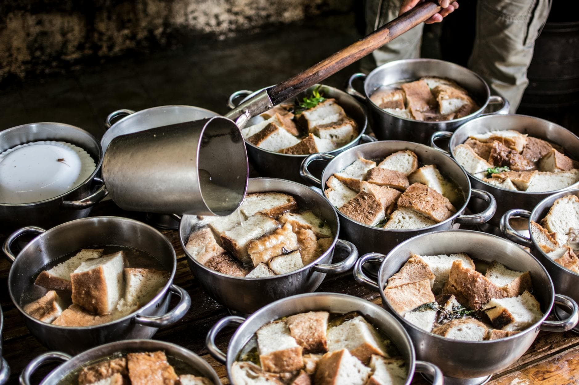 A rustic kitchen scene with pots of traditional bread soup being prepared in the Azores.