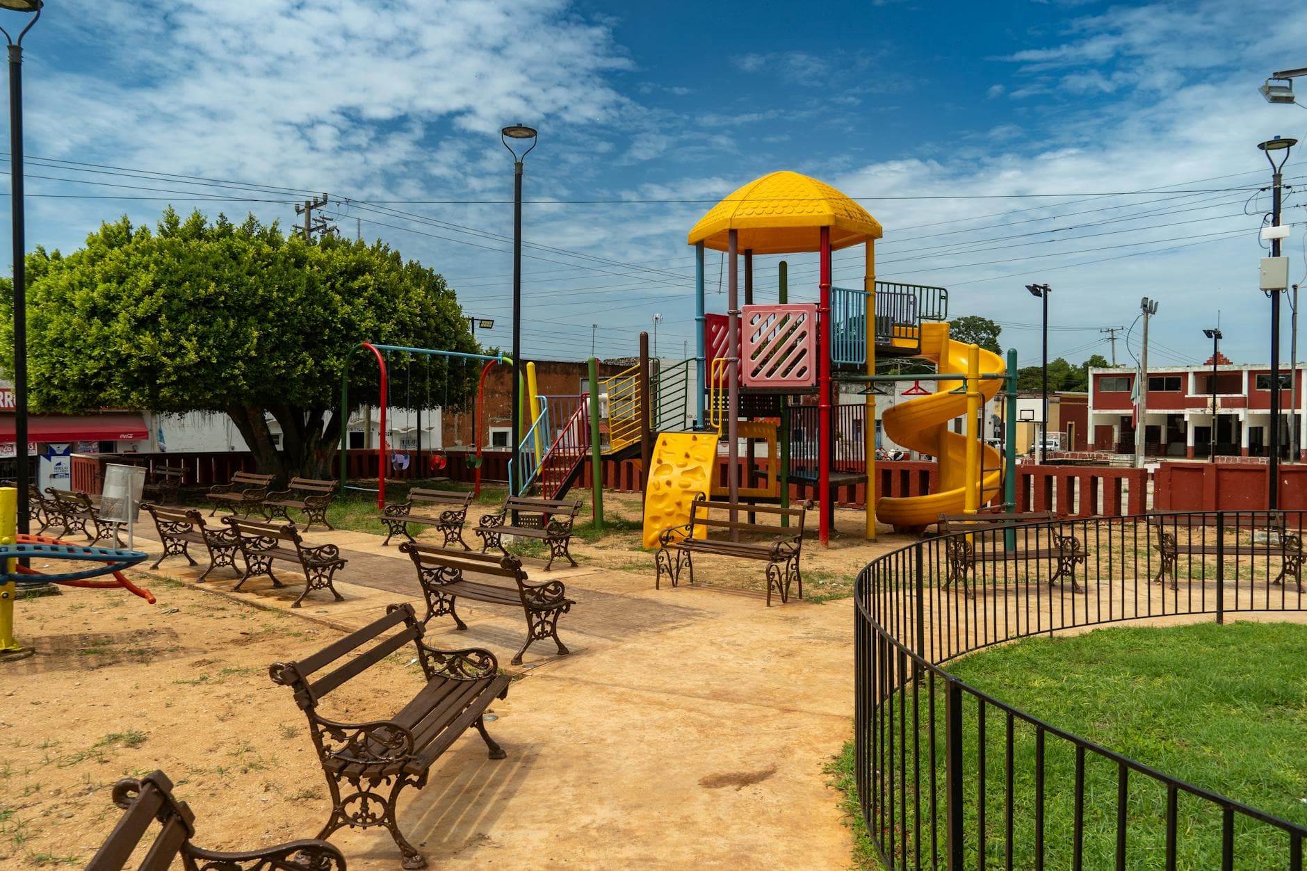 Vibrant playground with benches under a clear sky in Suma, Yucatán, Mexico.