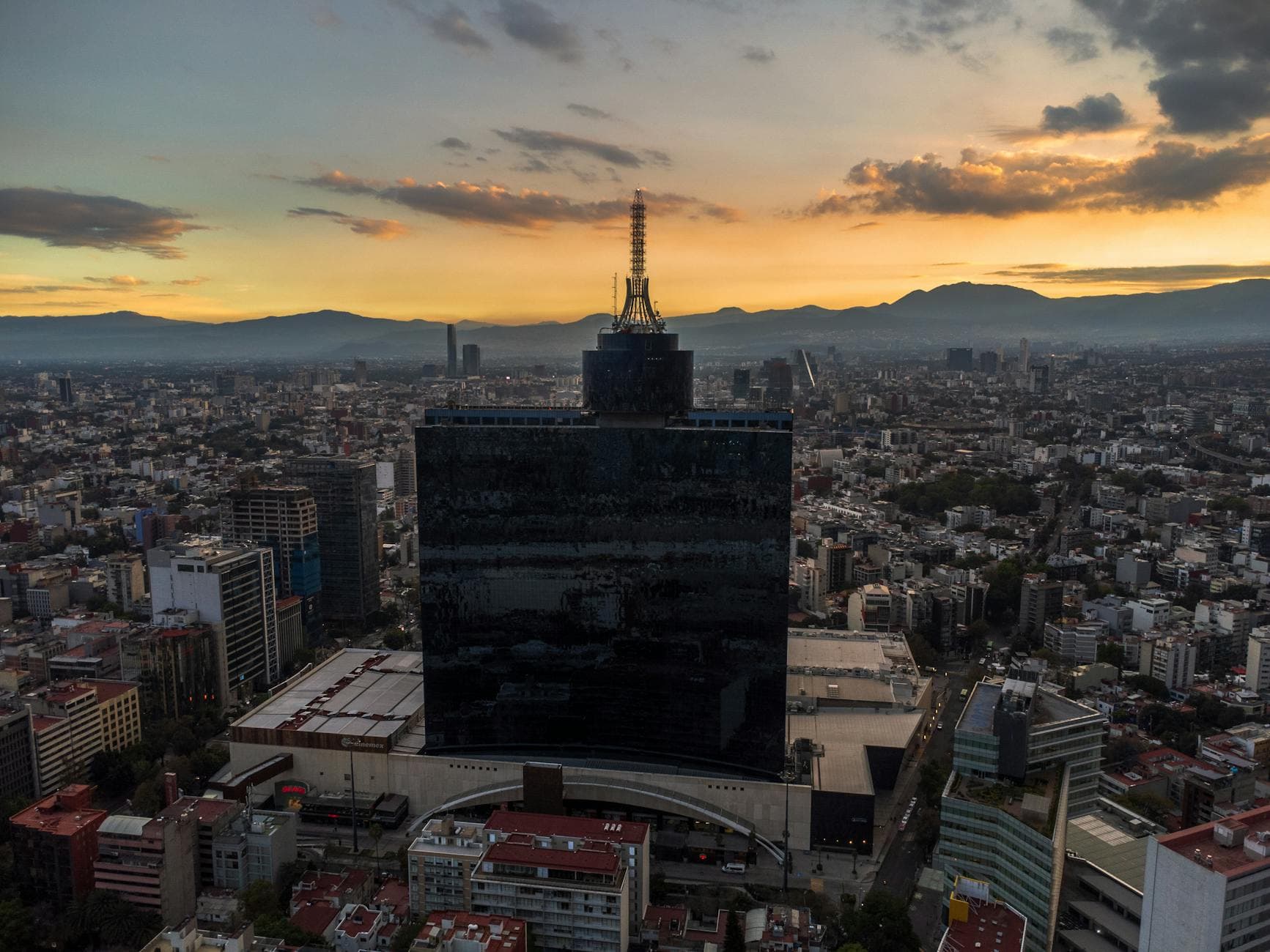 Aerial view of Ciudad de México's skyline with a dramatic sunset backdrop.