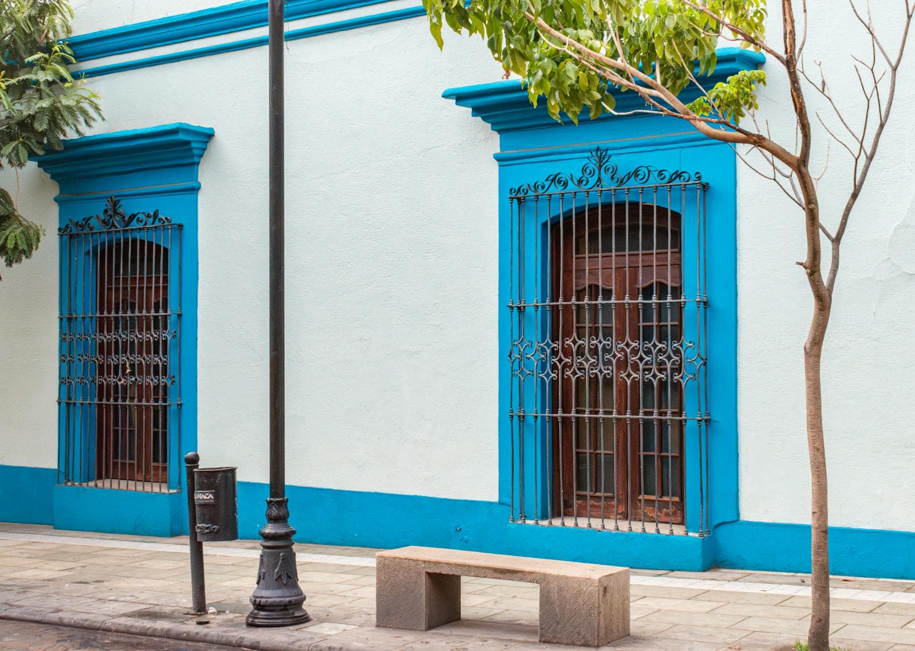 Colorful colonial building facade with wrought iron windows in Oaxaca, Mexico.