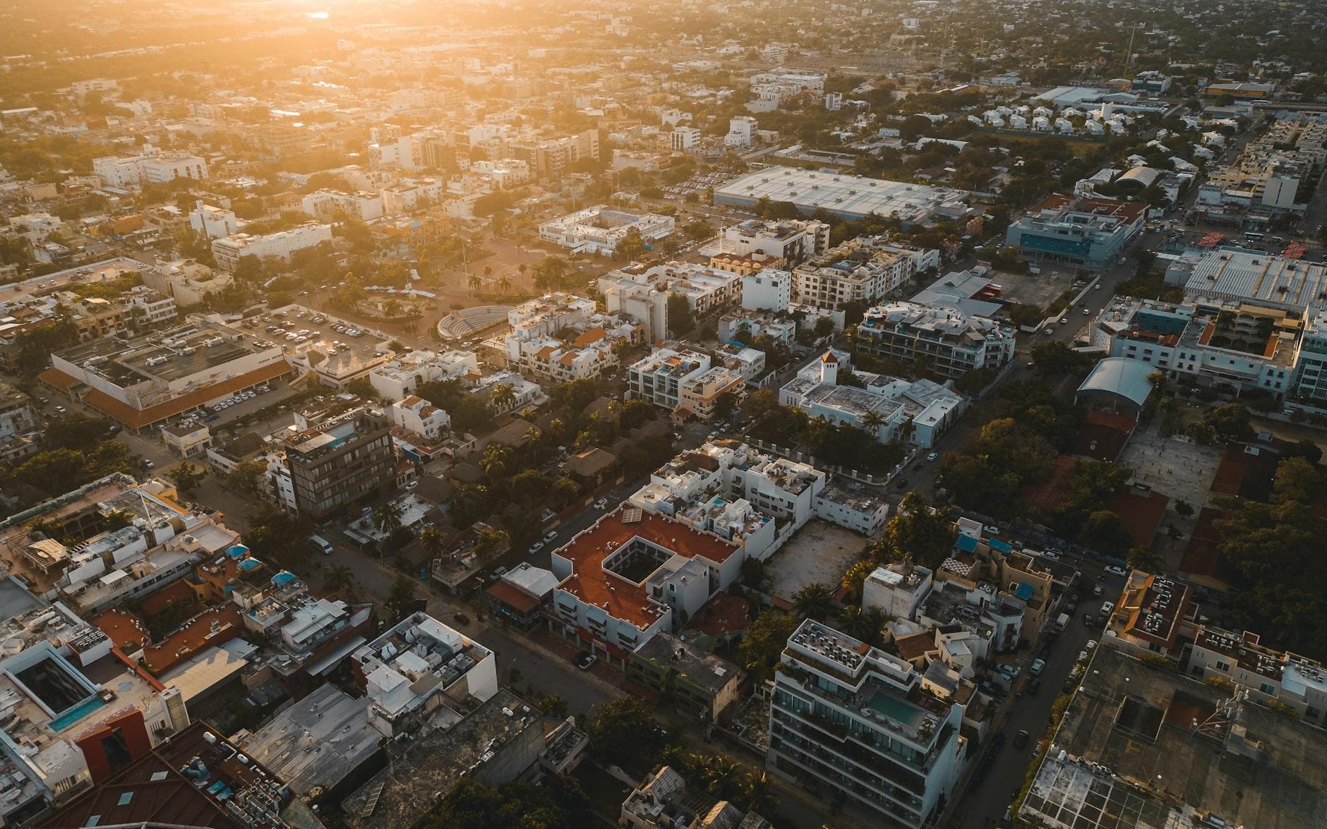 Stunning aerial cityscape of Playa del Carmen, Mexico at sunset, capturing urban life and architecture.