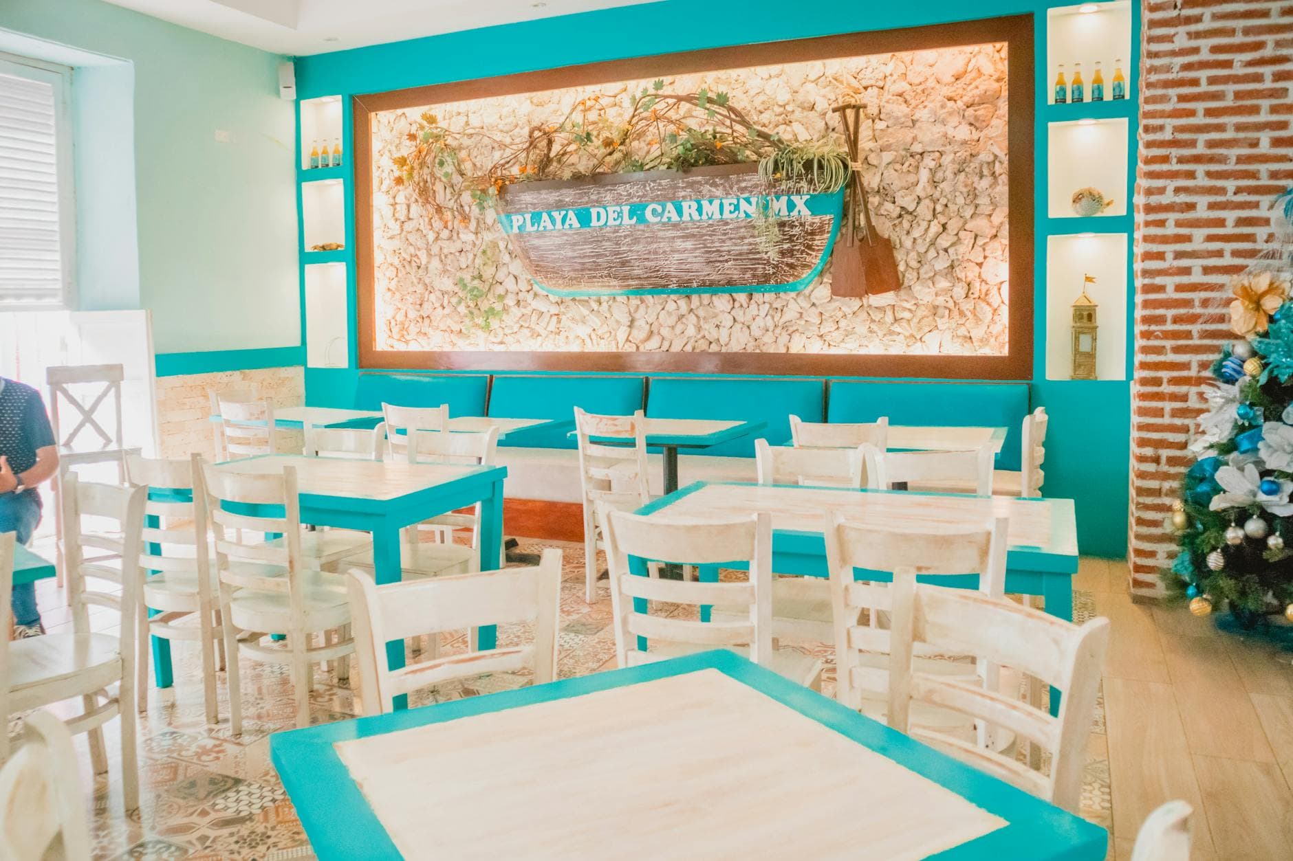Bright restaurant interior with coastal theme and wooden furniture in Playa Del Carmen.