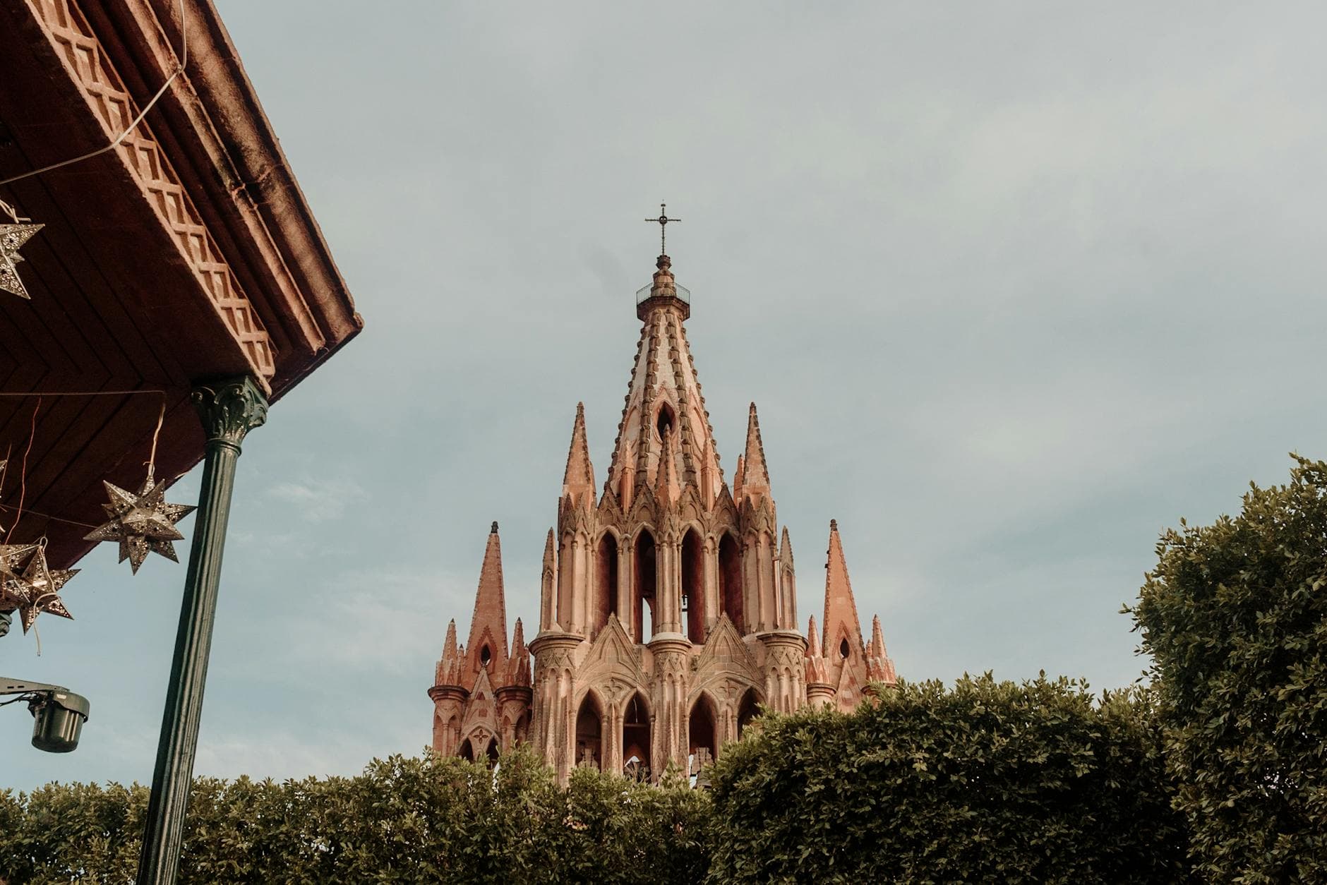 A beautiful view of the Parroquia de San Miguel Arcángel in San Miguel de Allende, framed by greenery.