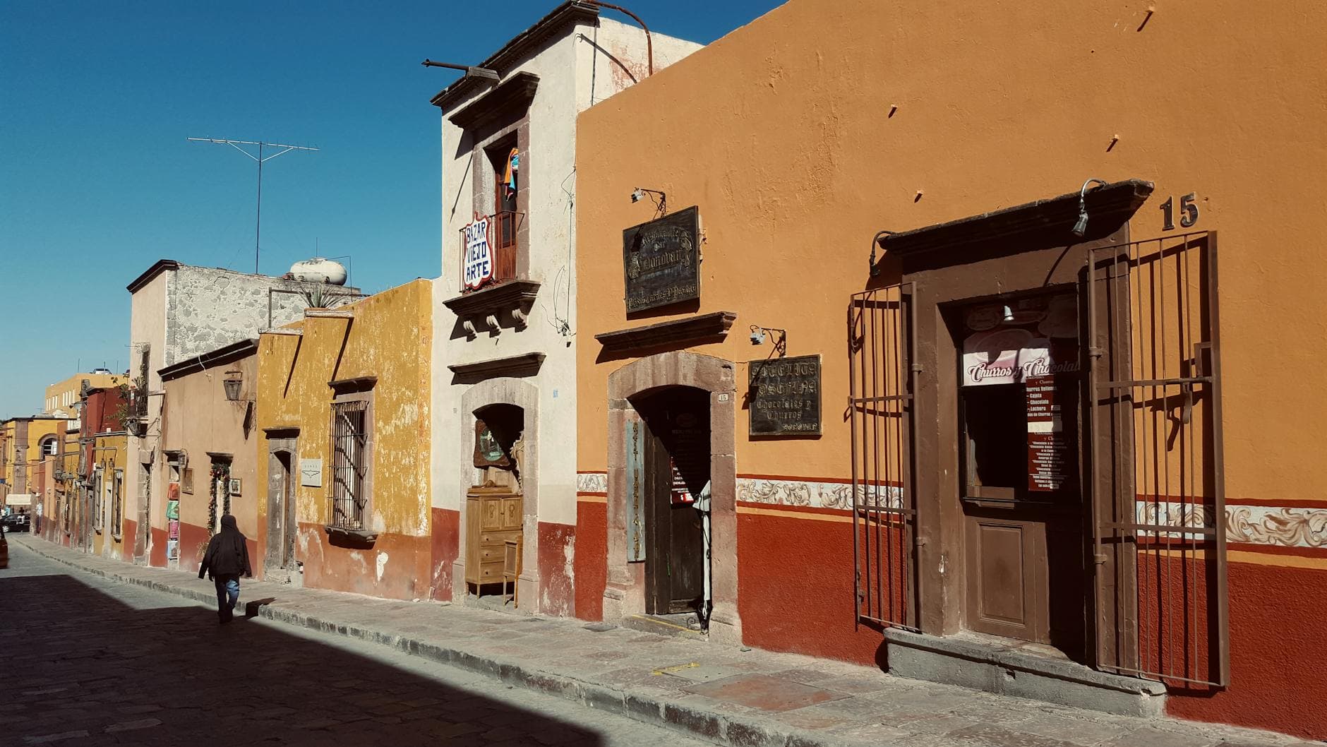 Bright colonial buildings line a street in San Miguel de Allende, Mexico.