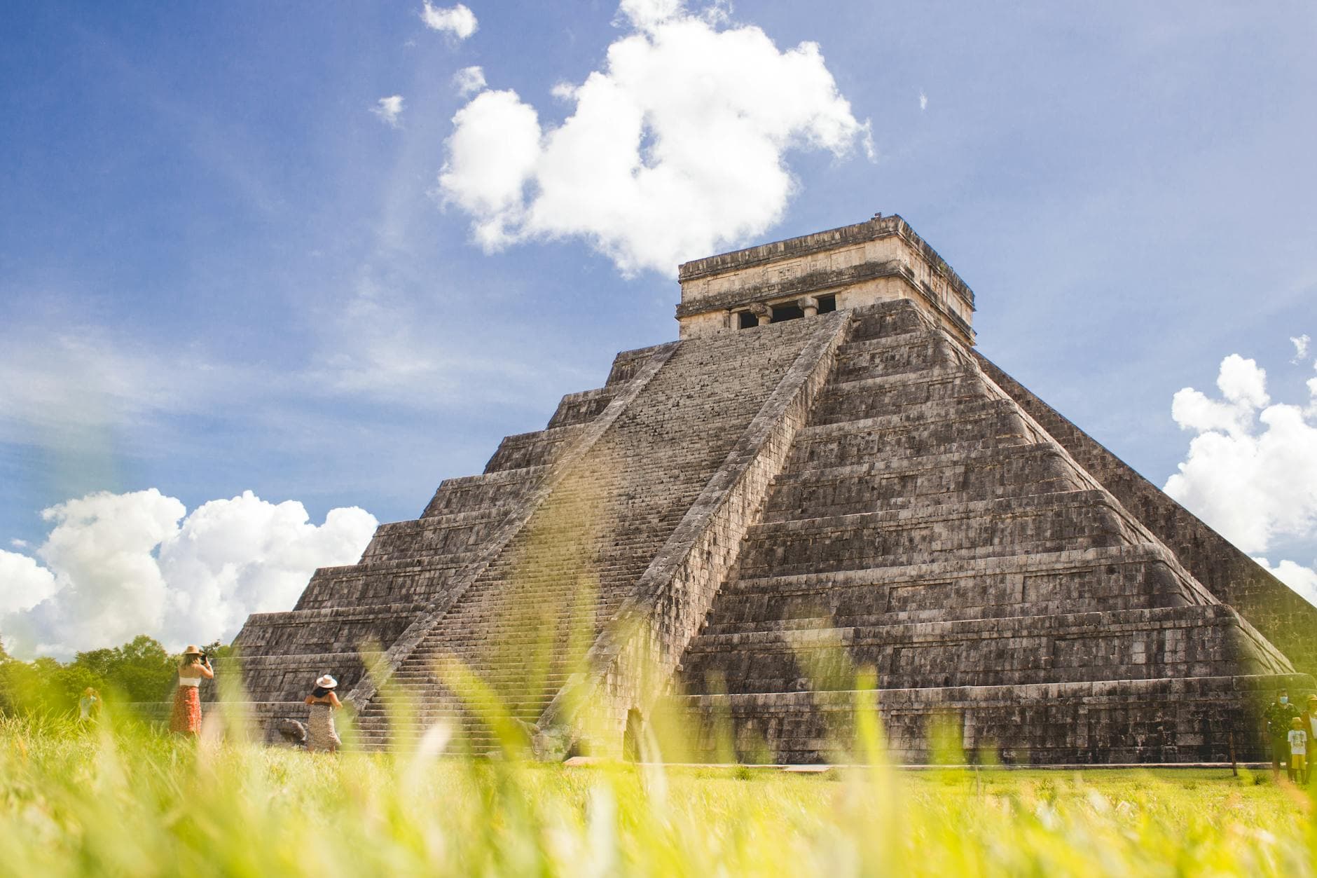 Capture of the iconic Temple of Kukulcán in Chichen Itza under a vibrant sky.
