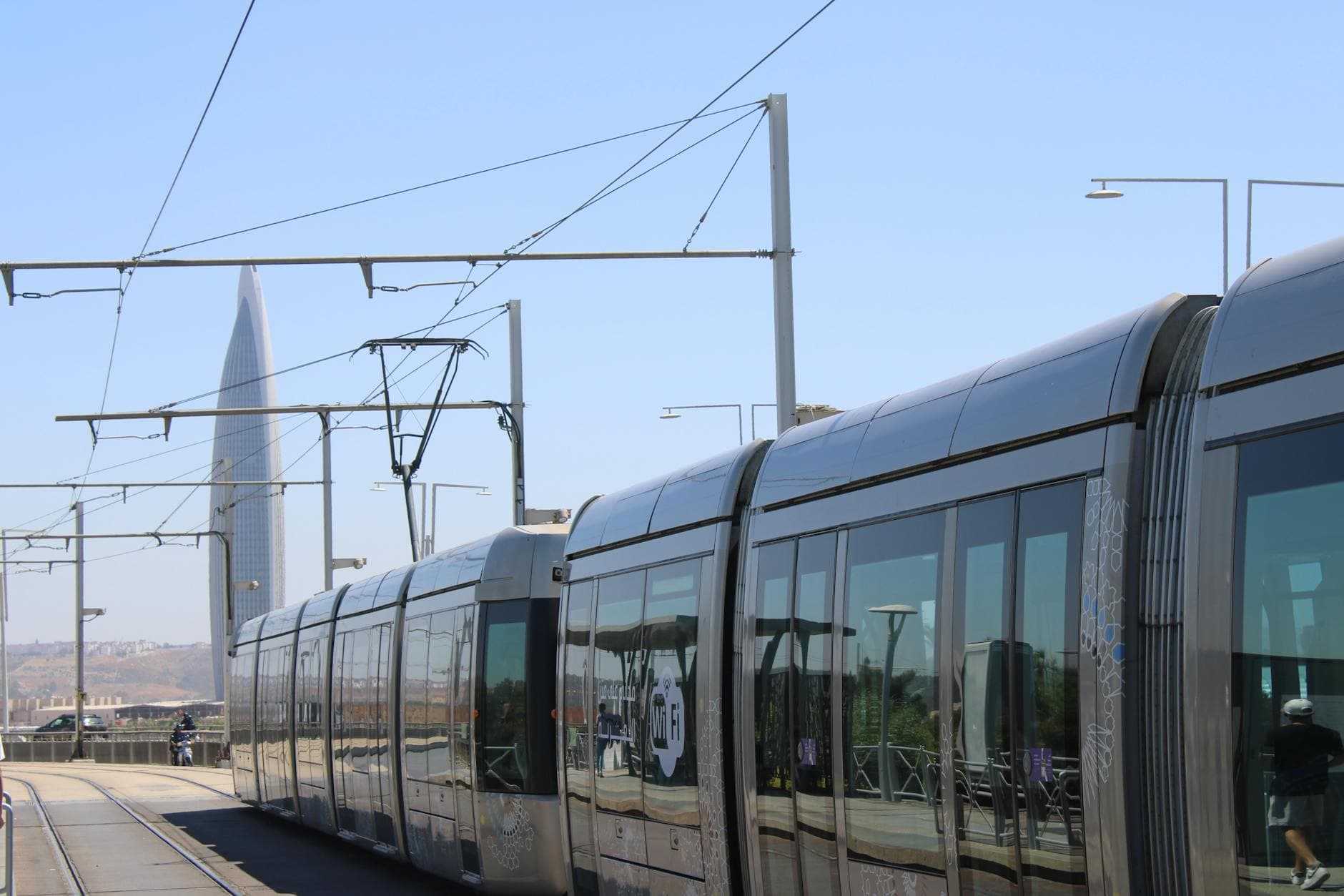 View of a modern tramway in Rabat with a distinctive tower in the background under clear blue skies.