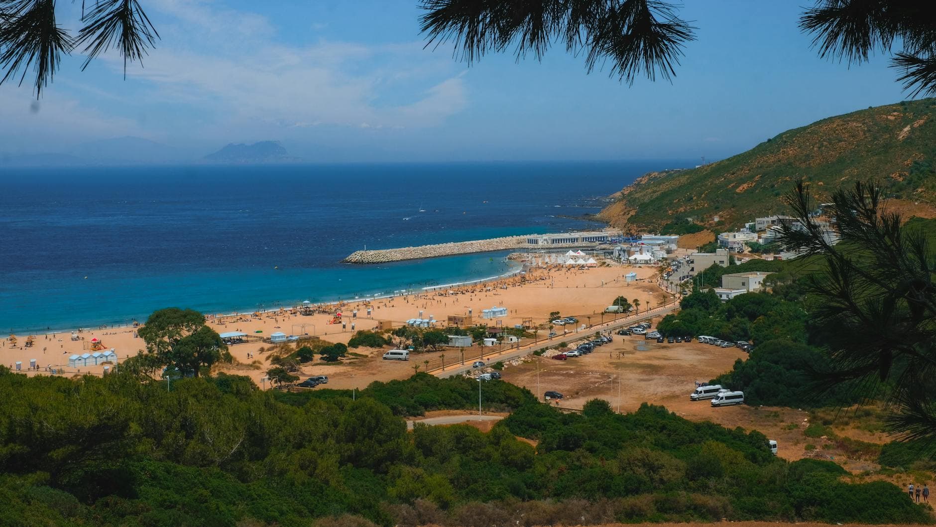 A breathtaking view of Tangier's vibrant beach and surrounding landscape under a clear blue sky.