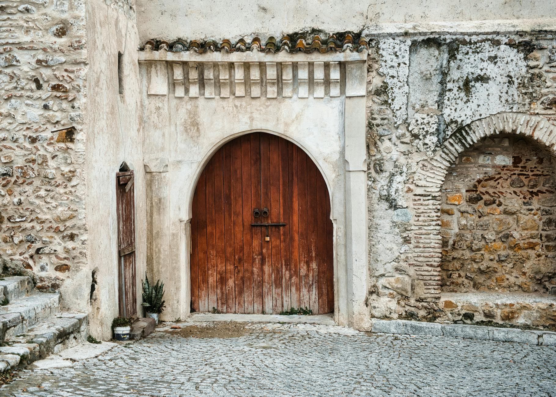 Explore the intricate wood and stonework of a traditional doorway in Tangier's medina, Morocco.