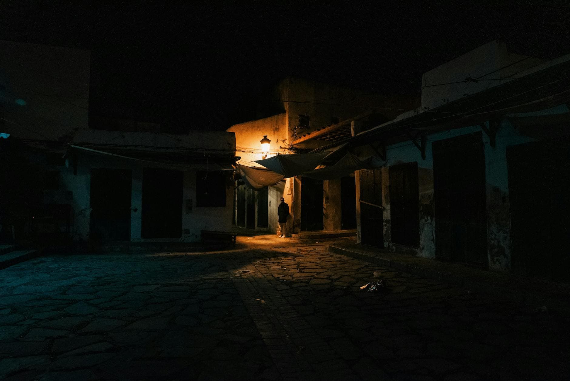 Eerie nighttime alley scene in Tangier's old town, showcasing architecture and dim lighting.