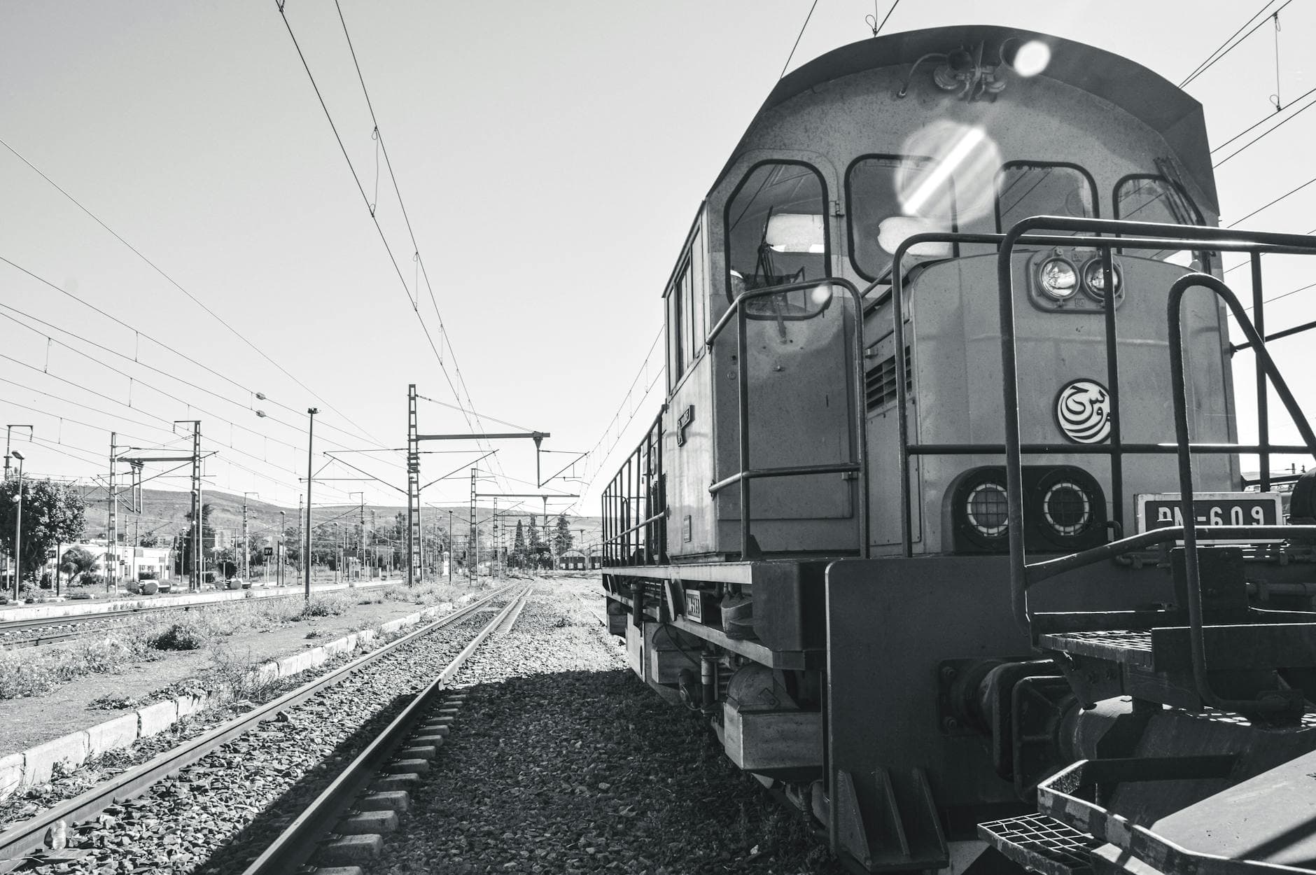 Monochrome photo of a vintage train on railway tracks in Tangier, Morocco, showcasing public transportation.