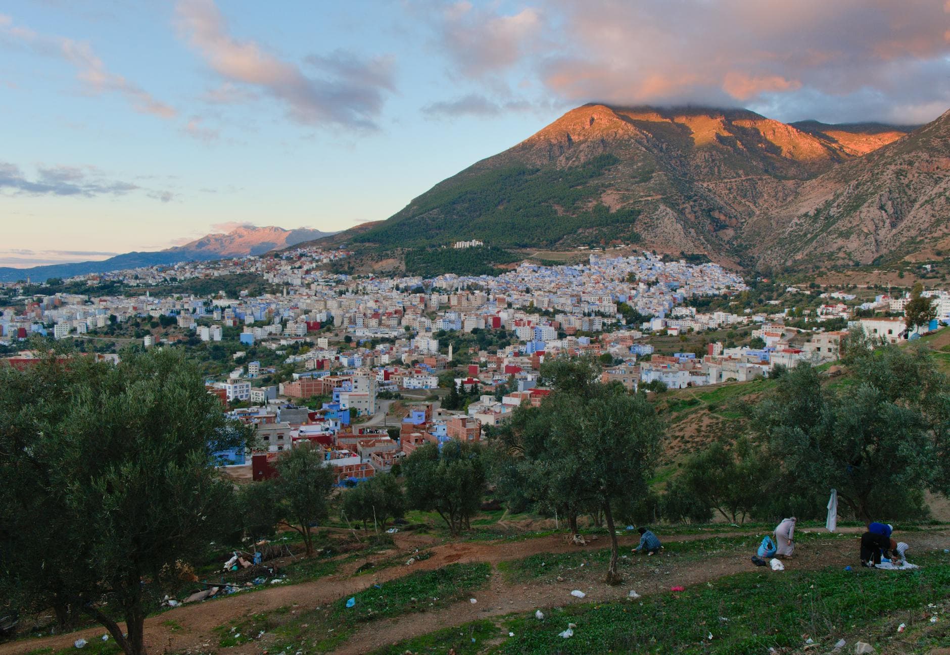 Scenic aerial view of a Moroccan town beneath the Atlas Mountains during sunset.
