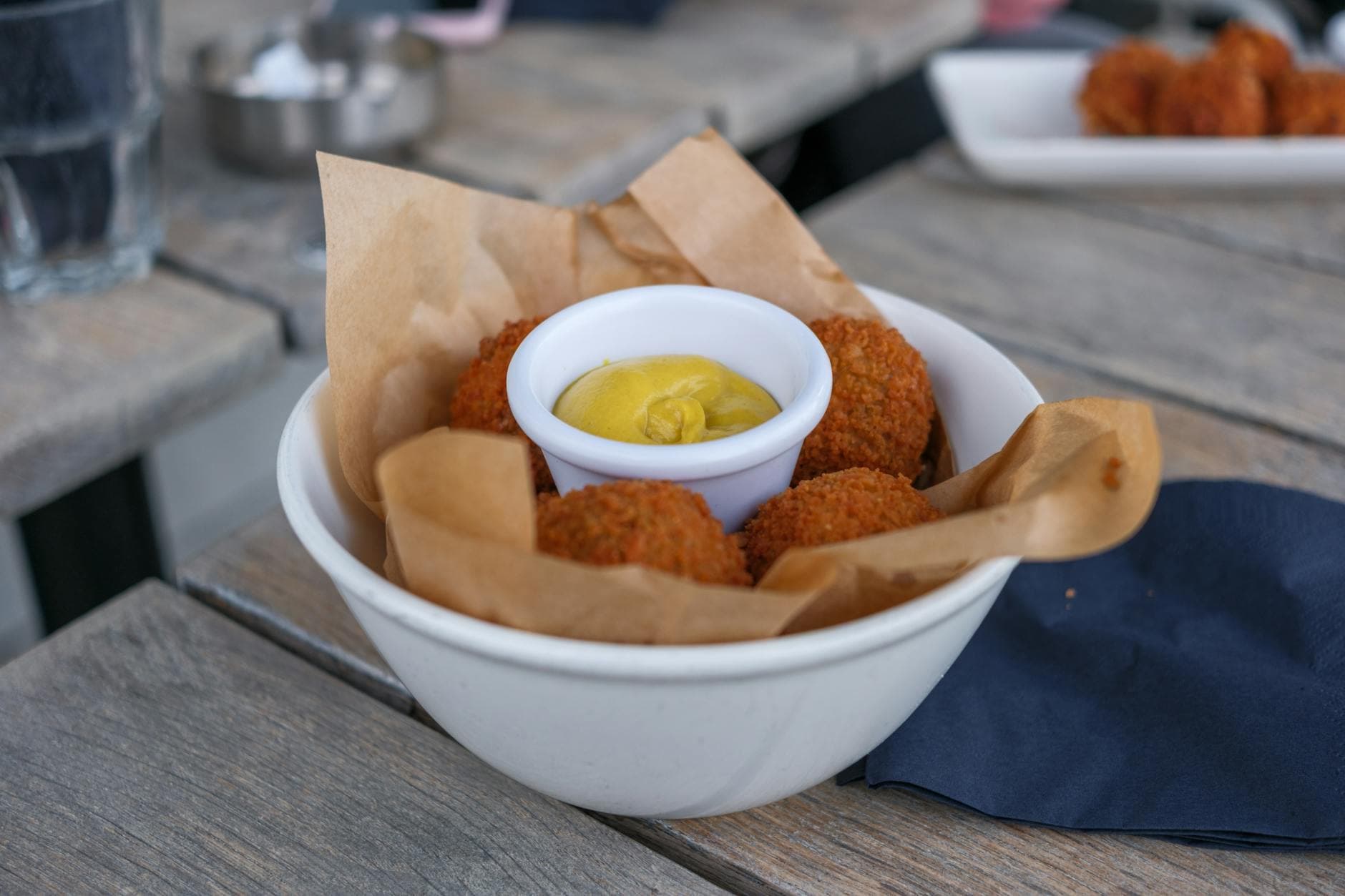 Tasty bowl of bitterballen with mustard, perfect for a quick bite in a cozy cafe setting.