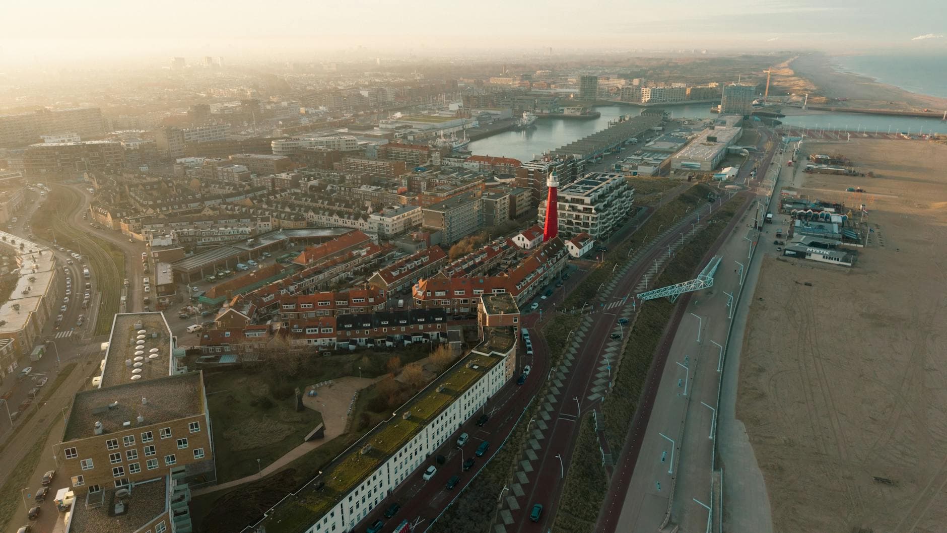 Stunning aerial view of The Hague's coastline featuring the iconic lighthouse and surrounding urban landscape.