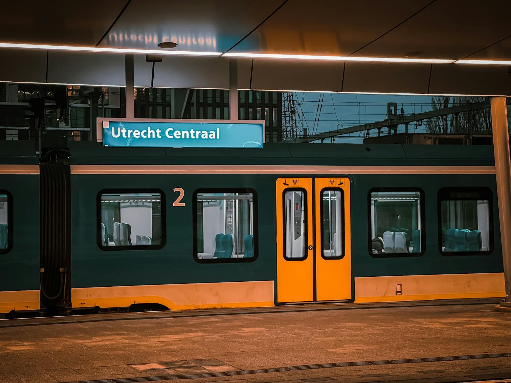 View of a train at Utrecht Centraal station in the Netherlands. Evening lighting enhances the scene.