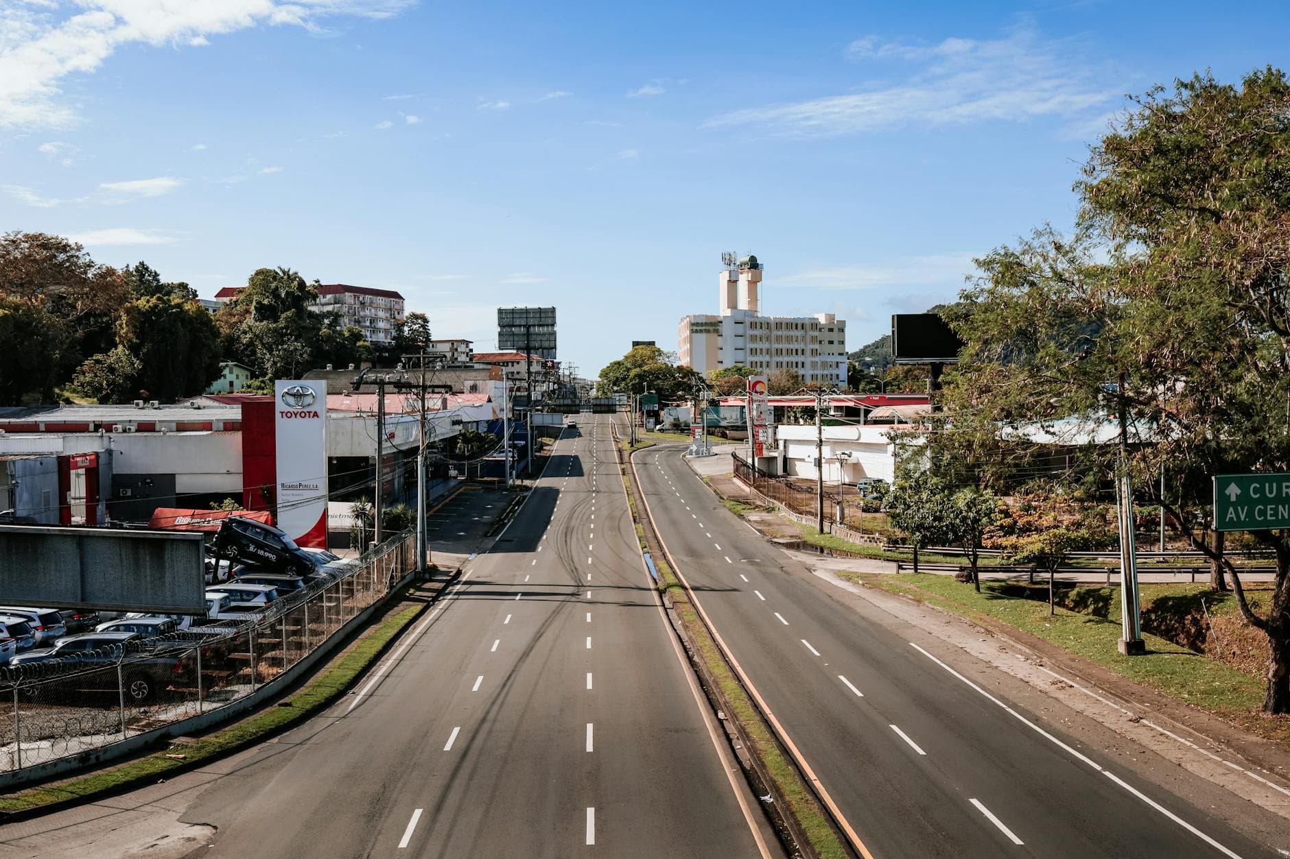 An aerial view of an empty urban highway in Panama City with buildings and greenery.