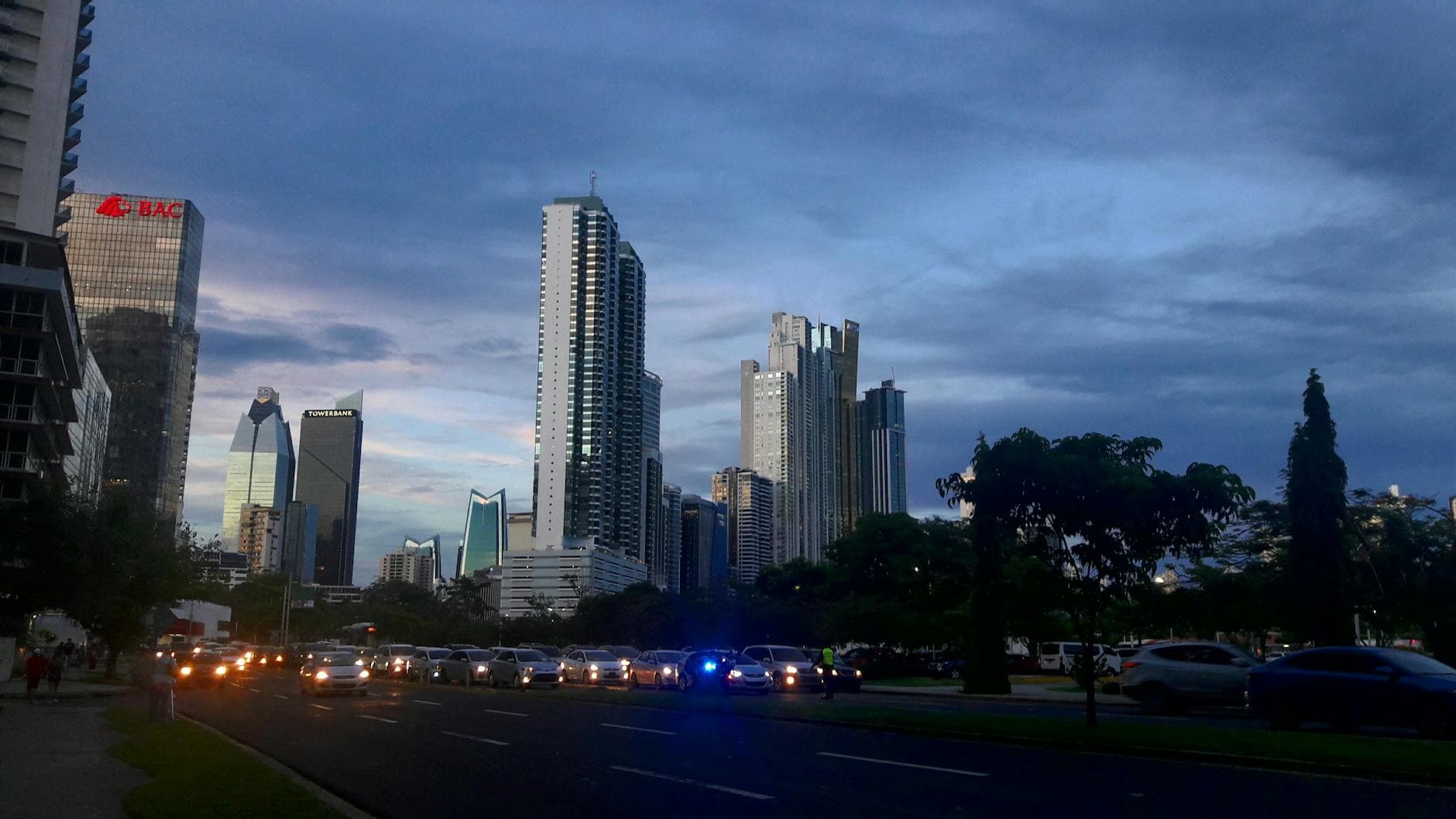 Panama City skyline with modern skyscrapers and traffic during twilight.
