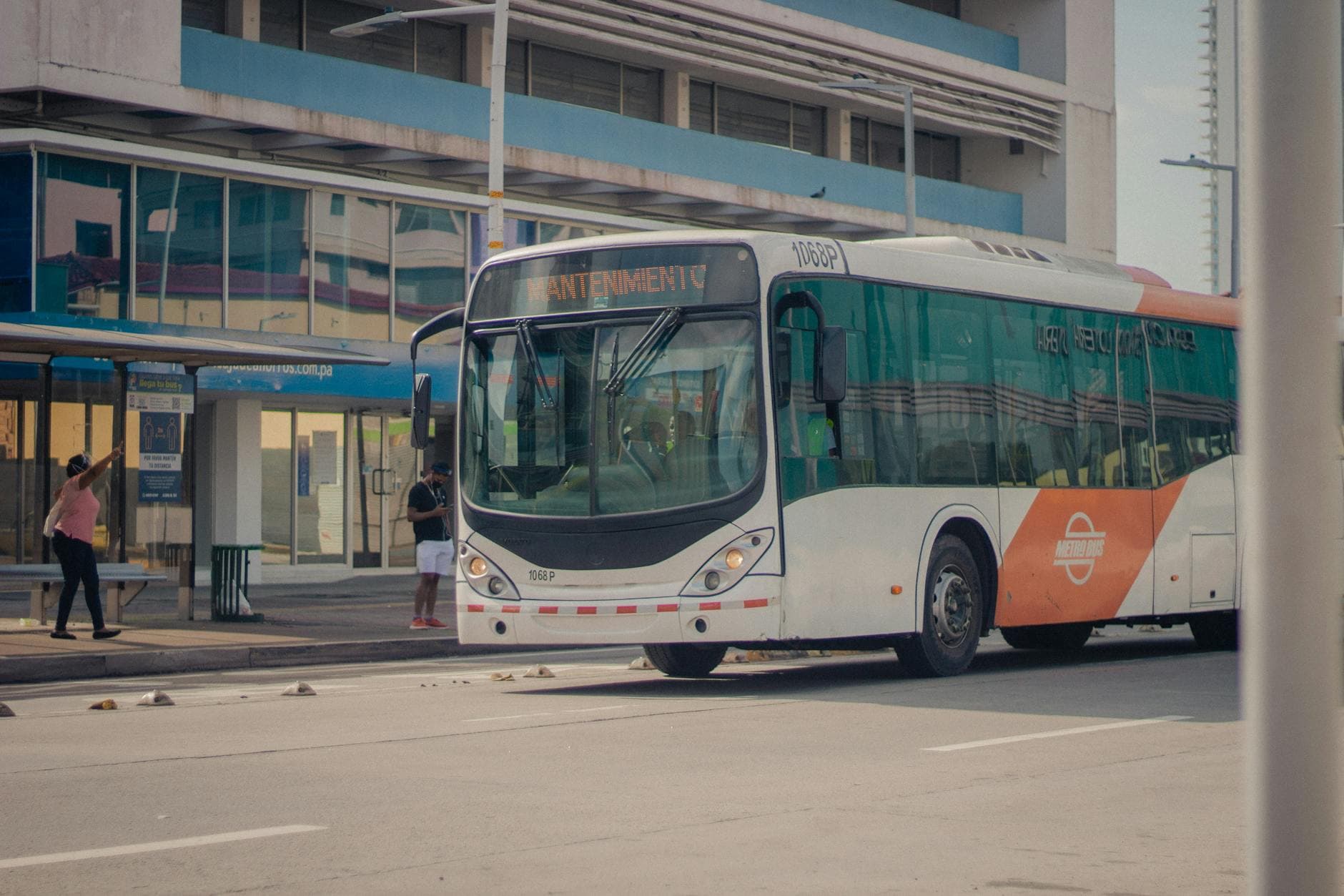 City bus at a stop with passengers boarding, capturing urban public transit scene.
