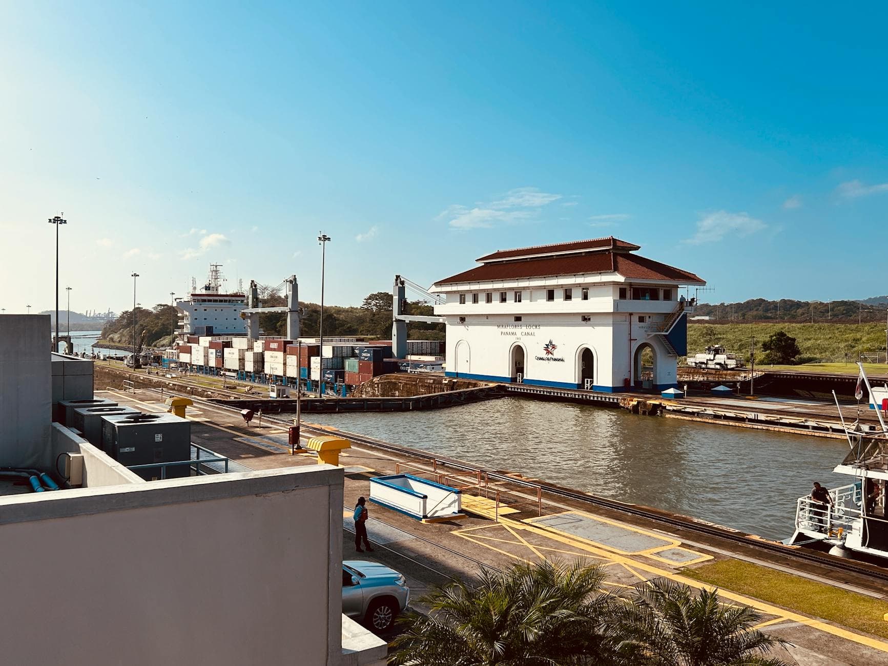 Scenic view of the Miraflores Locks at Panama Canal with cargo ship on a sunny day.