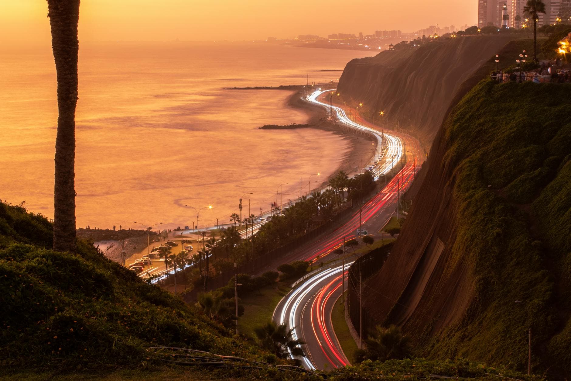 Beautiful sunset view of Lima coastline with light trails of cars along the Pacific Ocean.