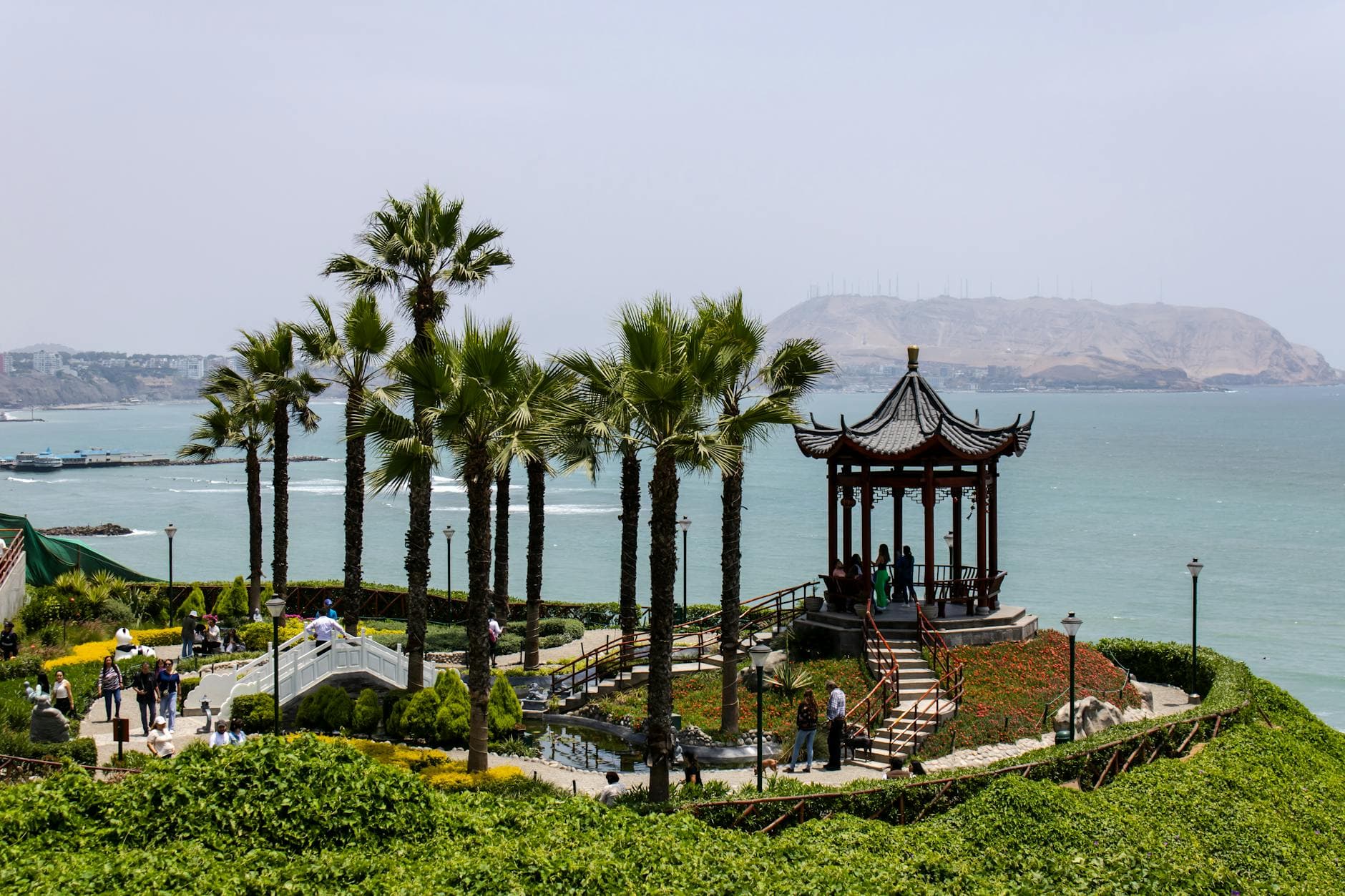 Scenic view of a gazebo surrounded by palm trees and ocean in Lima, Peru.