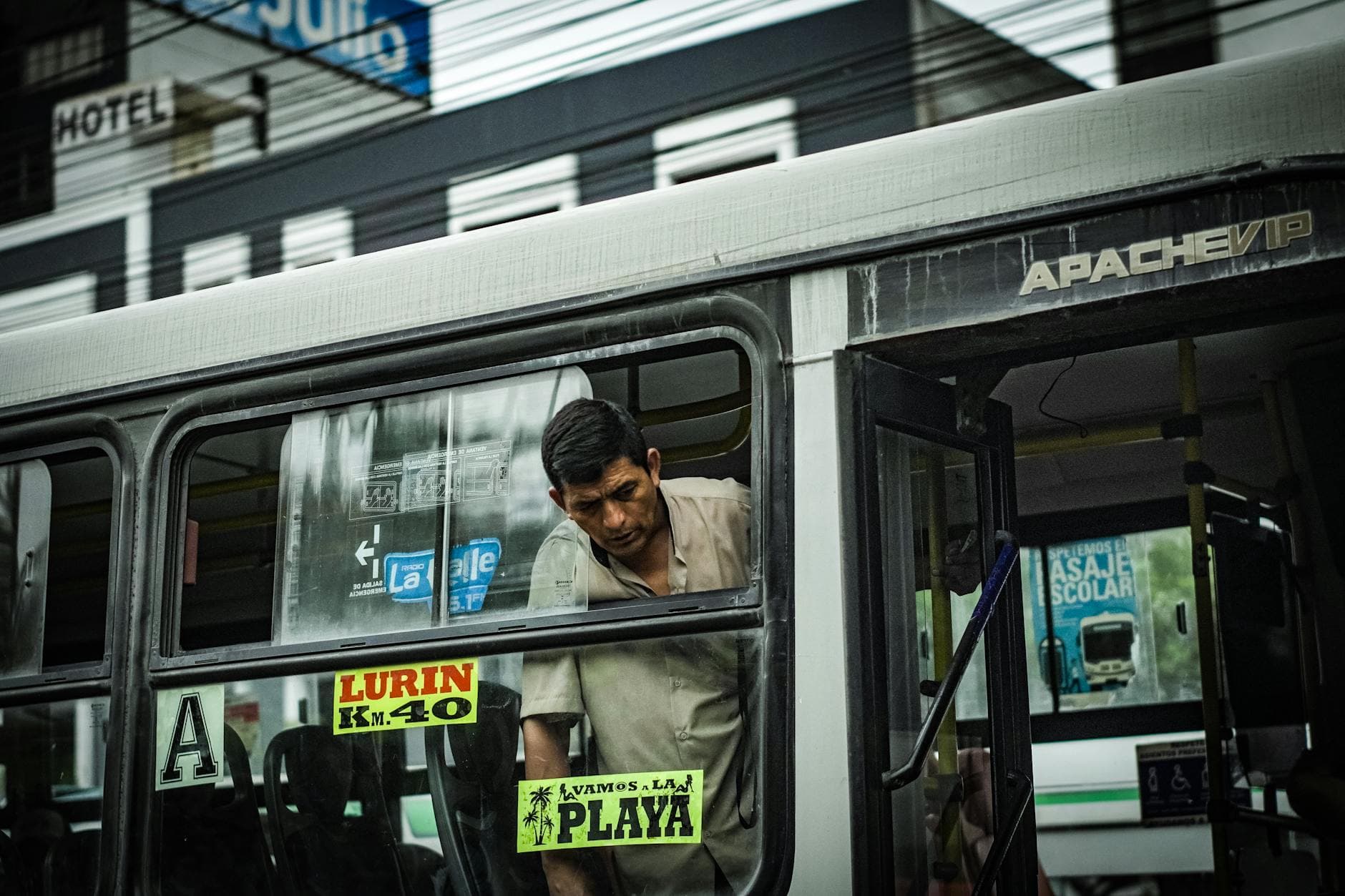 A man onboard a bus in Lima, highlighting the vibrant street culture. Captured in an urban setting.