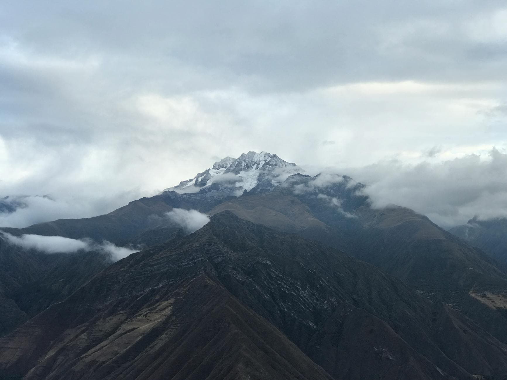 Breathtaking view of snow-covered peaks and clouds in the Andes Mountains, Cusco, Peru.