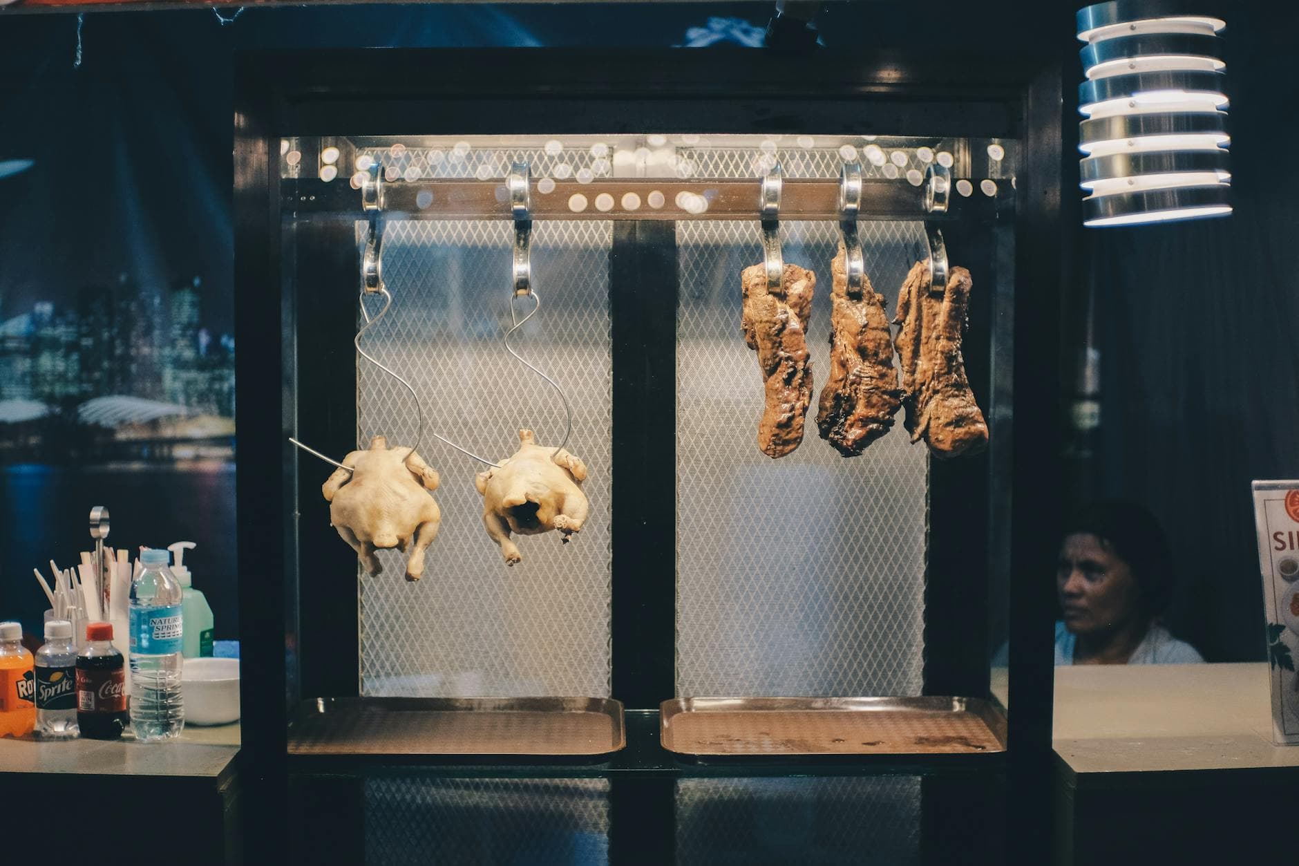 Street food display of roast chicken and pork in a Cebu City restaurant, showcasing local cuisine.