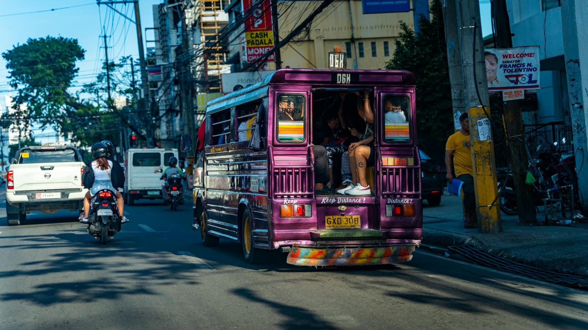 Busy urban street scene with a colorful jeepney and traffic in Cebu City, Philippines.