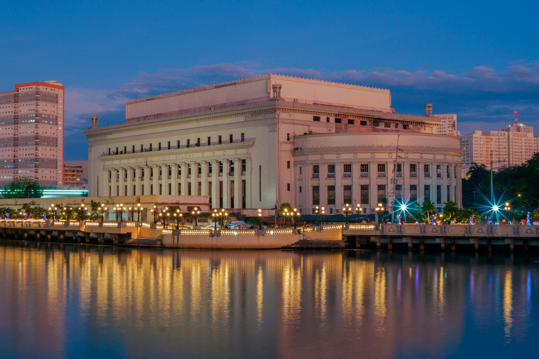 The iconic Manila Central Post Office building reflected in the Pasig River at twilight in Metro Manila, Philippines.