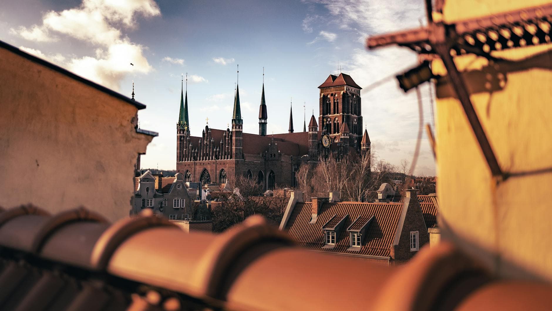 Scenic view of St. Mary's Church in Gdańsk, Poland, with a gothic architectural style set against a bright sky.