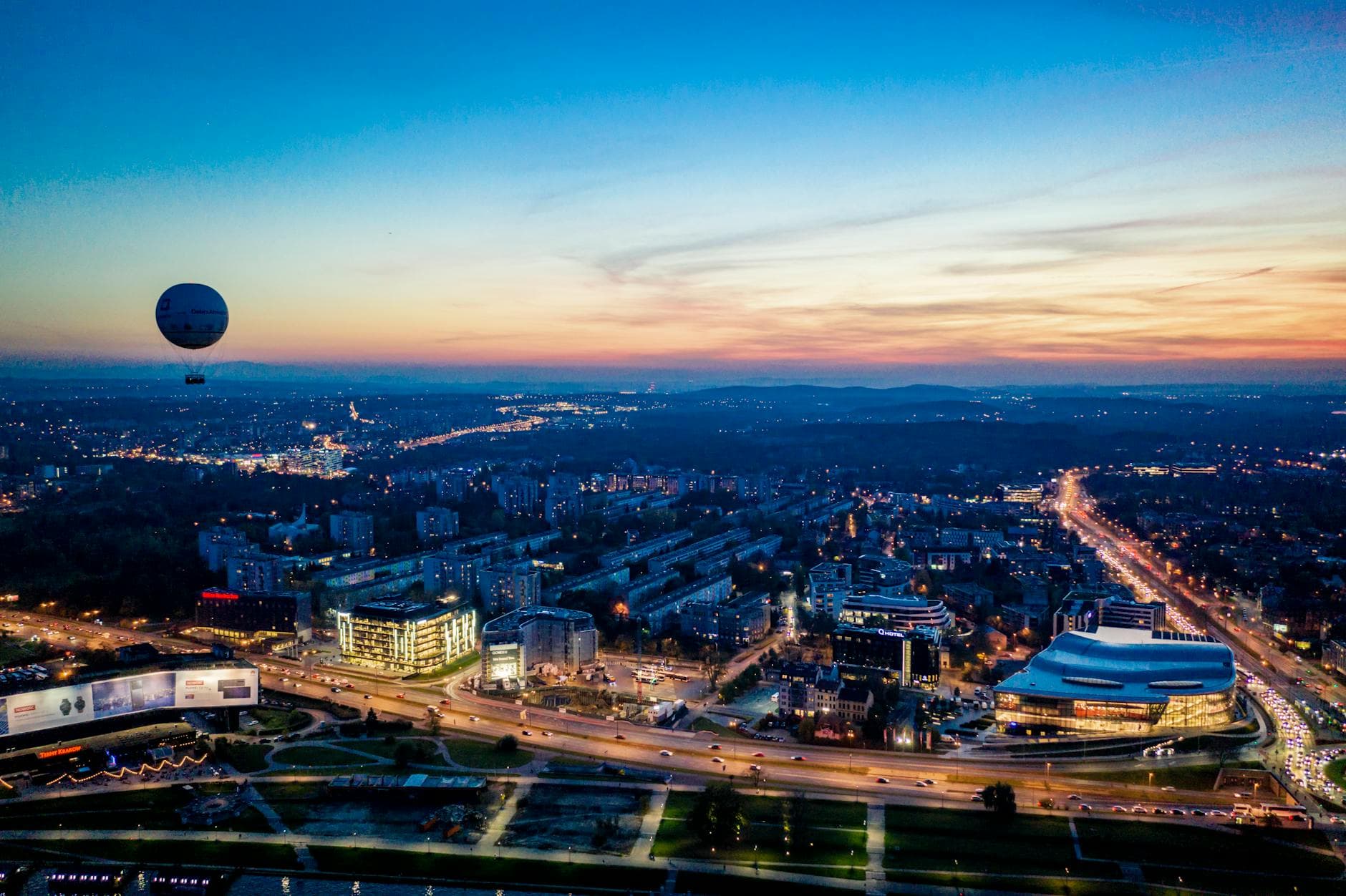Stunning aerial shot of Kraków skyline during sunset with a hot air balloon.