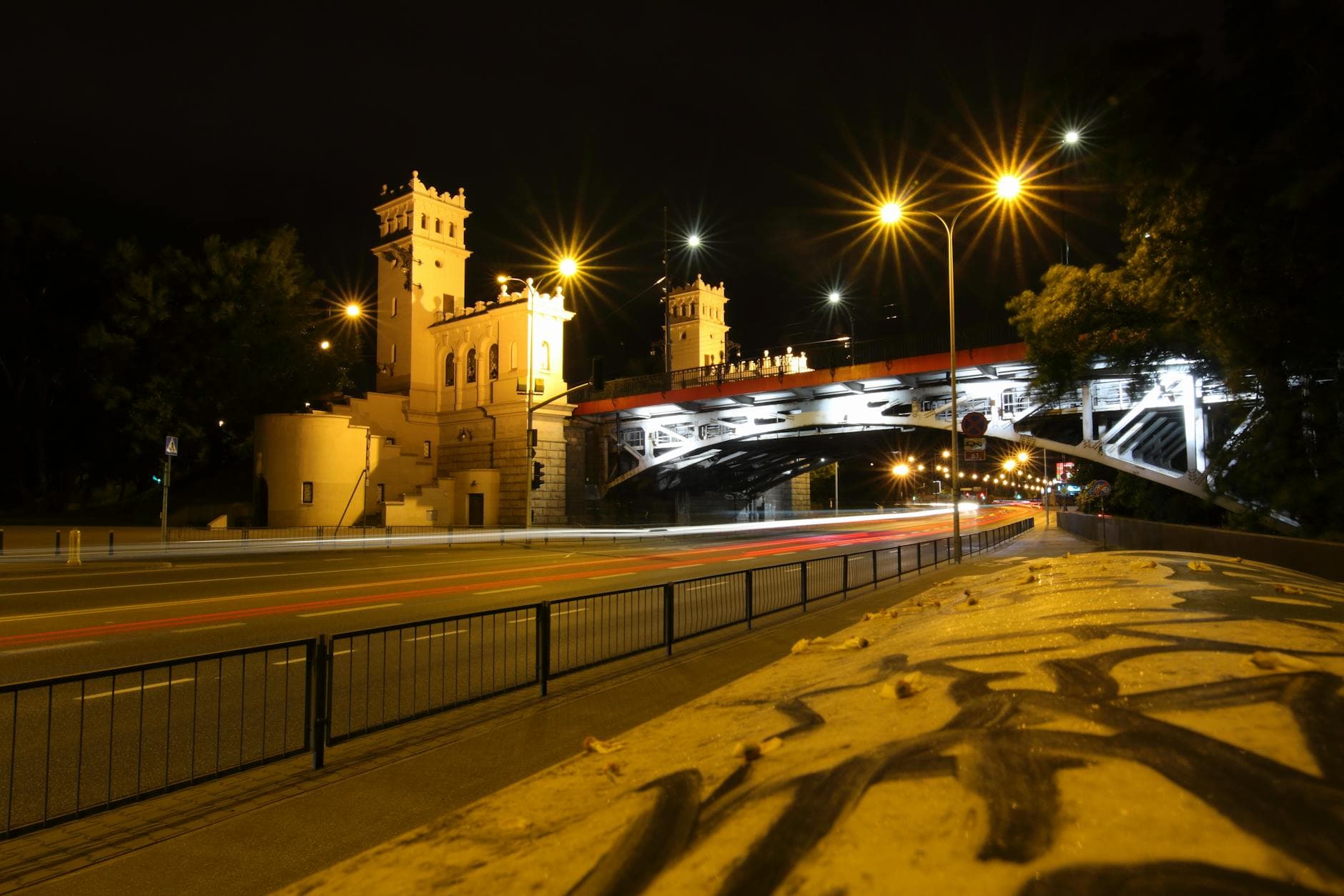 A vibrant nighttime scene of a Warsaw bridge with striking illumination and city lights.