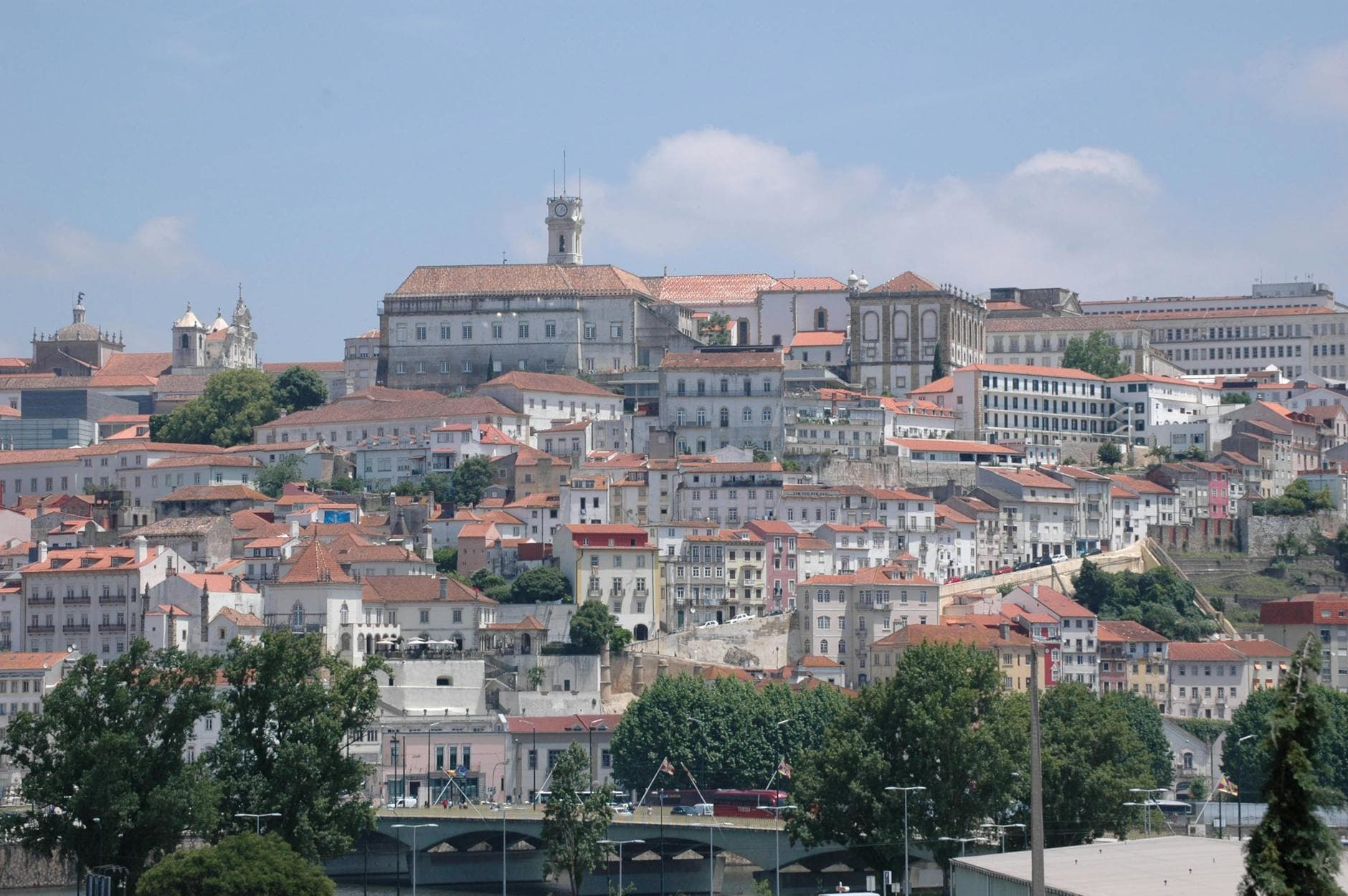 Explore Coimbra's stunning historic architecture with vibrant red rooftops and lush greenery.