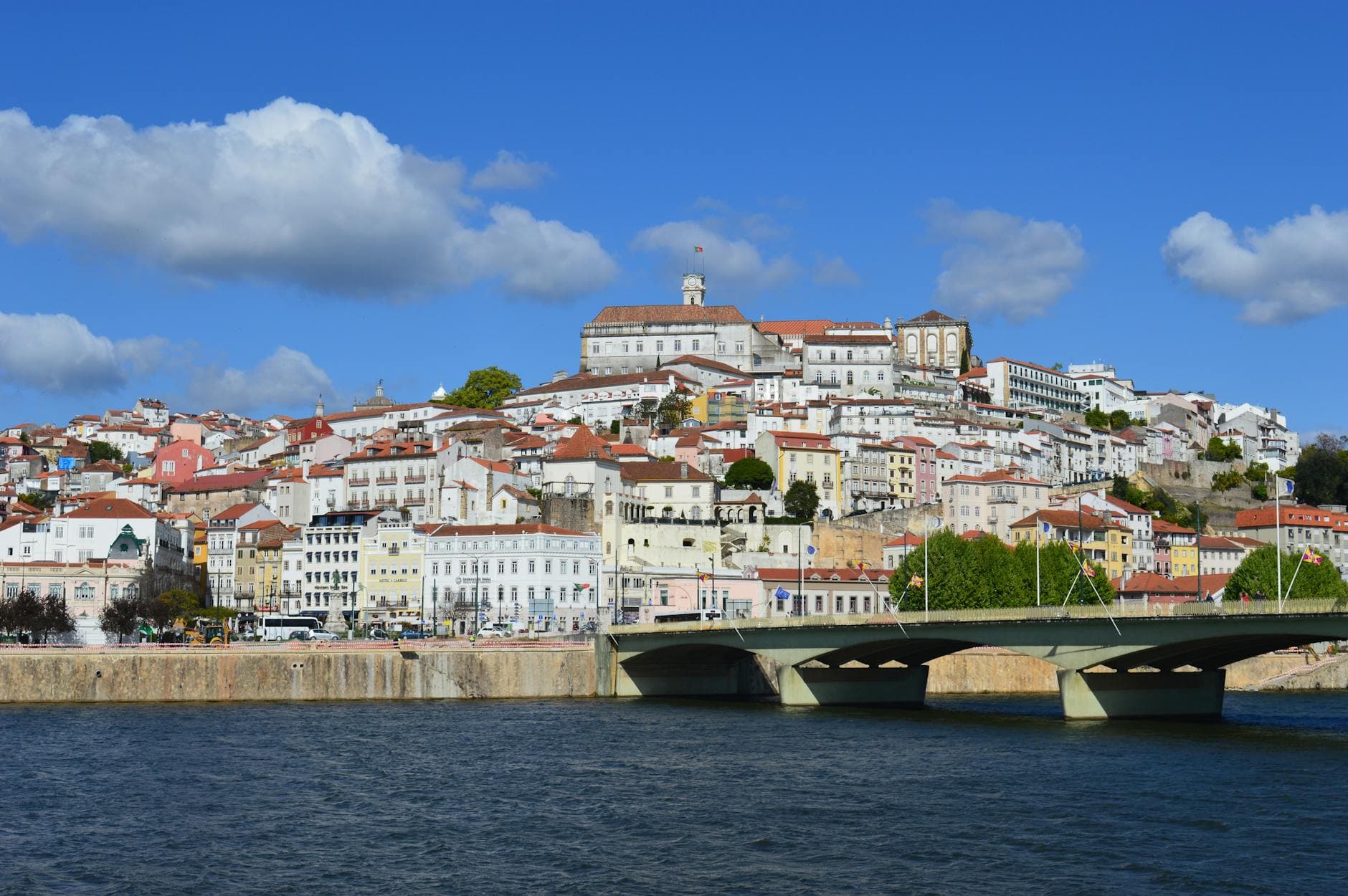 Panoramic view of Coimbra, Portugal showcasing historic architecture along the Mondego River.