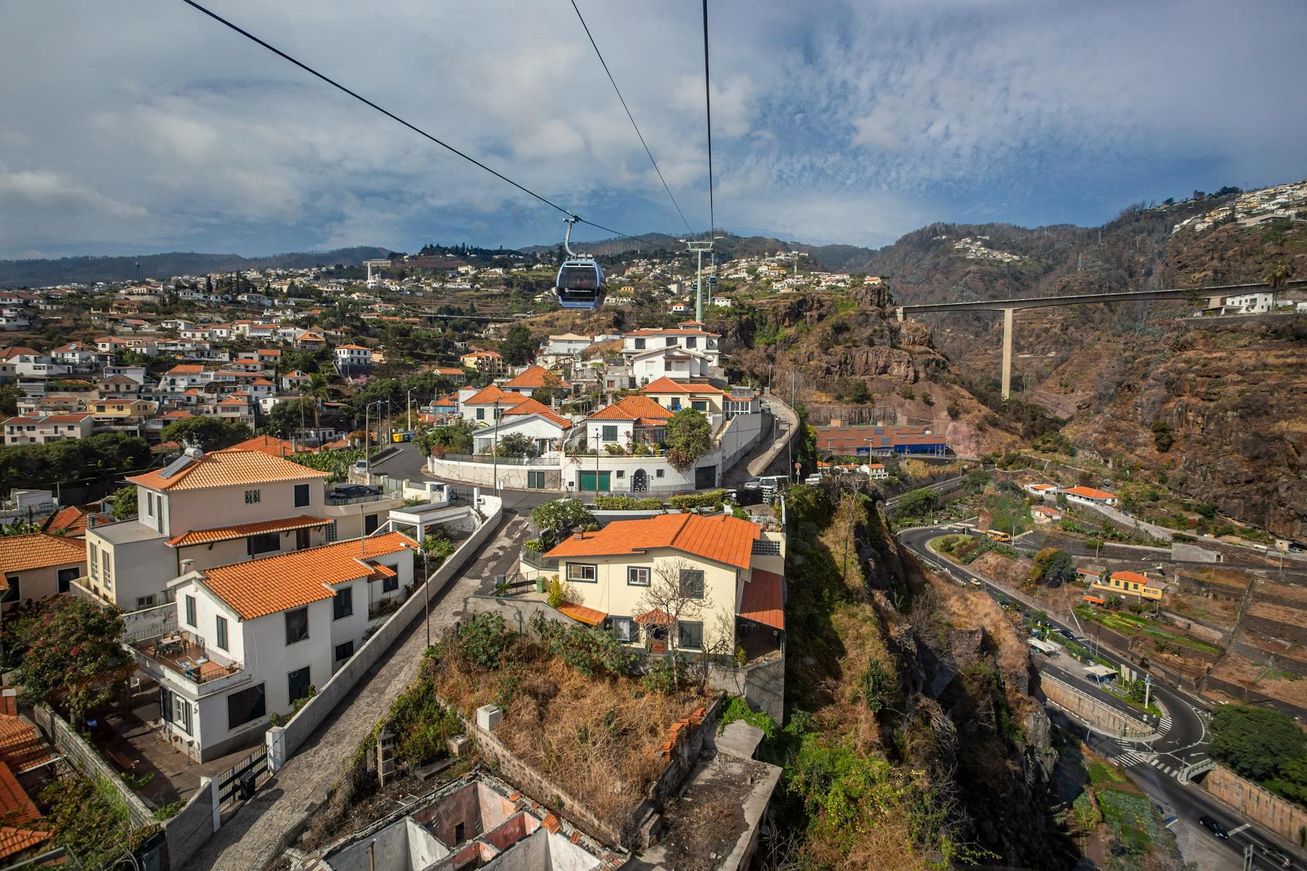 Explore the stunning aerial view of Funchal, Madeira with its iconic cable car and vibrant urban landscape.