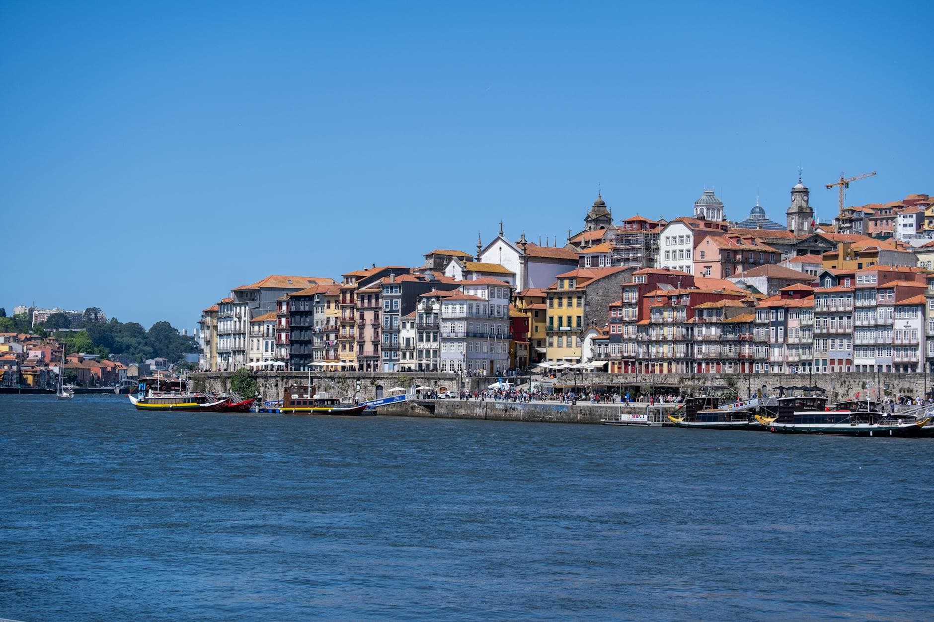 Explore the colorful and historic waterfront of Porto's Ribeira District on a sunny day.