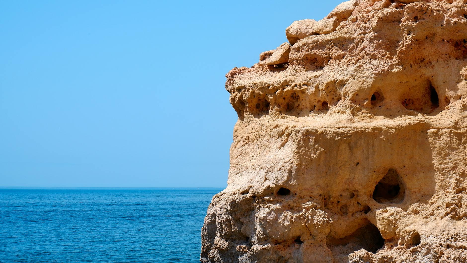 A breathtaking view of limestone cliffs against the azure Atlantic Ocean in Algarve, Portugal.