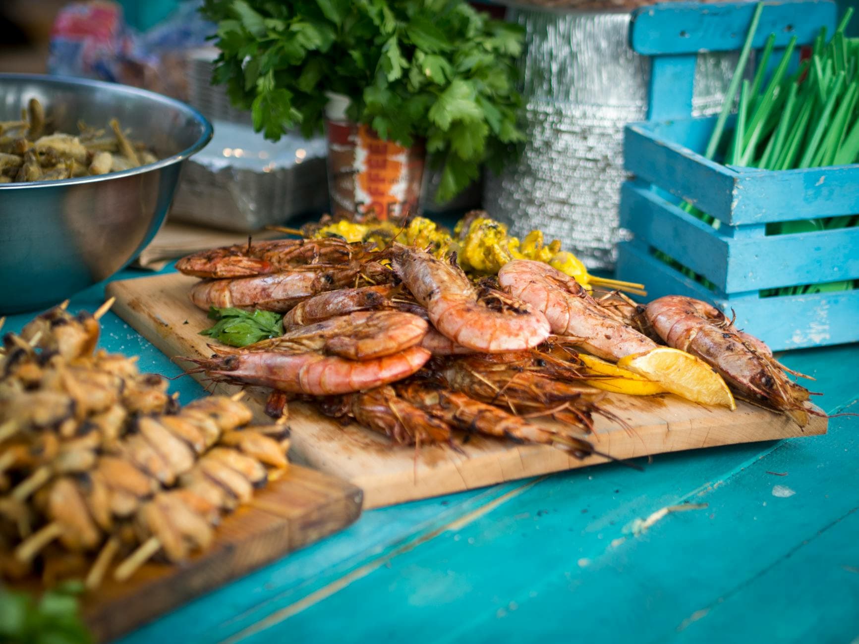 Assorted grilled seafood and skewers on a rustic wooden board, perfect for summer outdoor dining.