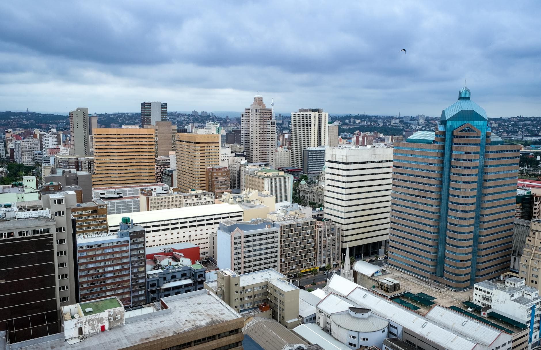 Aerial view of Durban's modern skyline with towering skyscrapers under overcast skies.