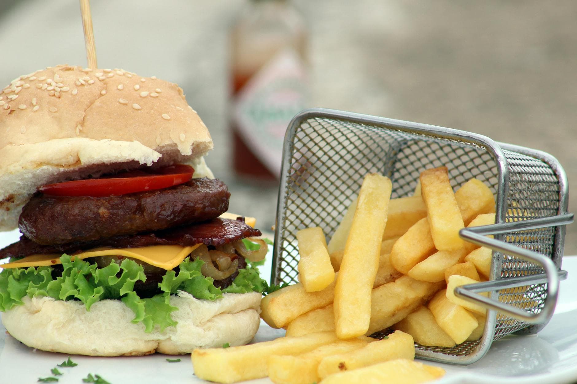 Delicious gourmet burger with crispy fries in a basket, perfect for satisfying cravings.
