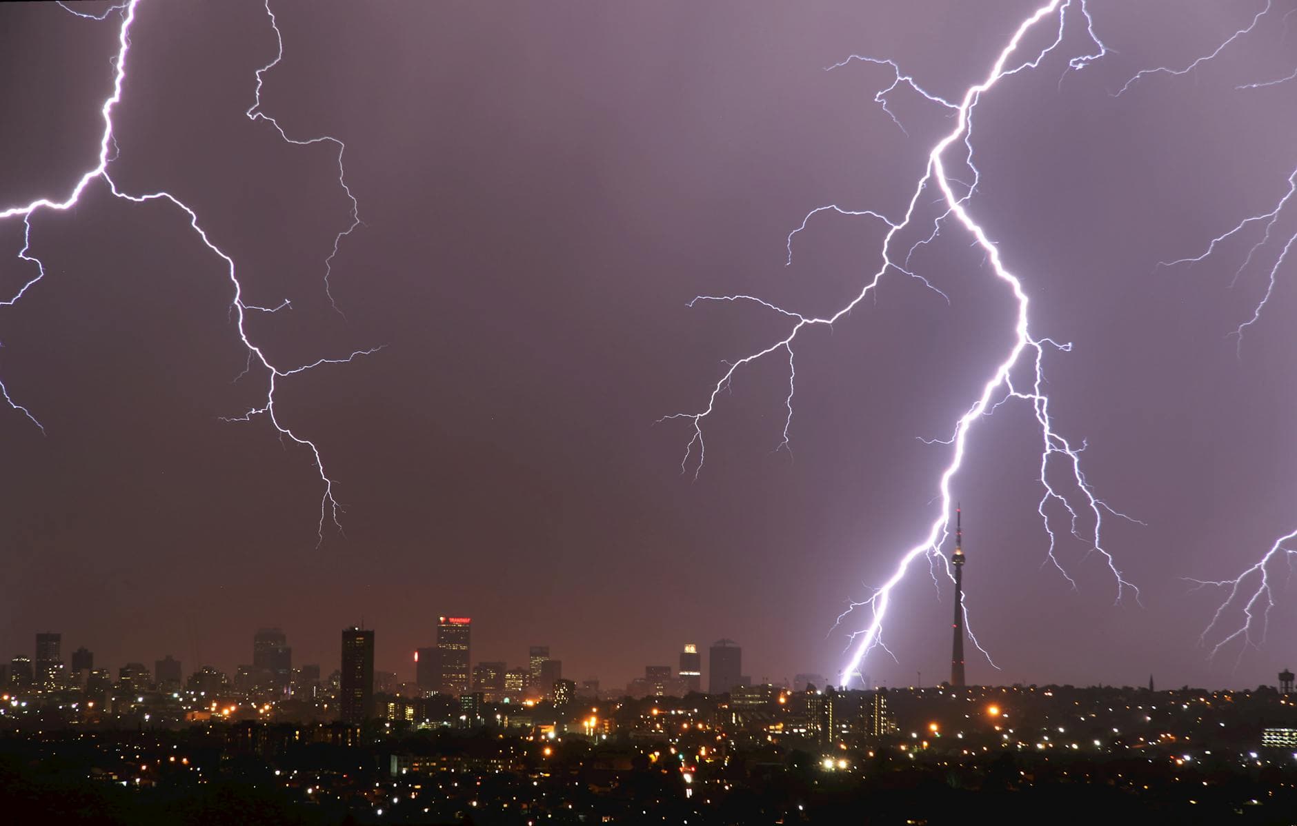 Breathtaking lightning storm illuminating the Johannesburg city skyline during night time, showcasing dramatic weather.