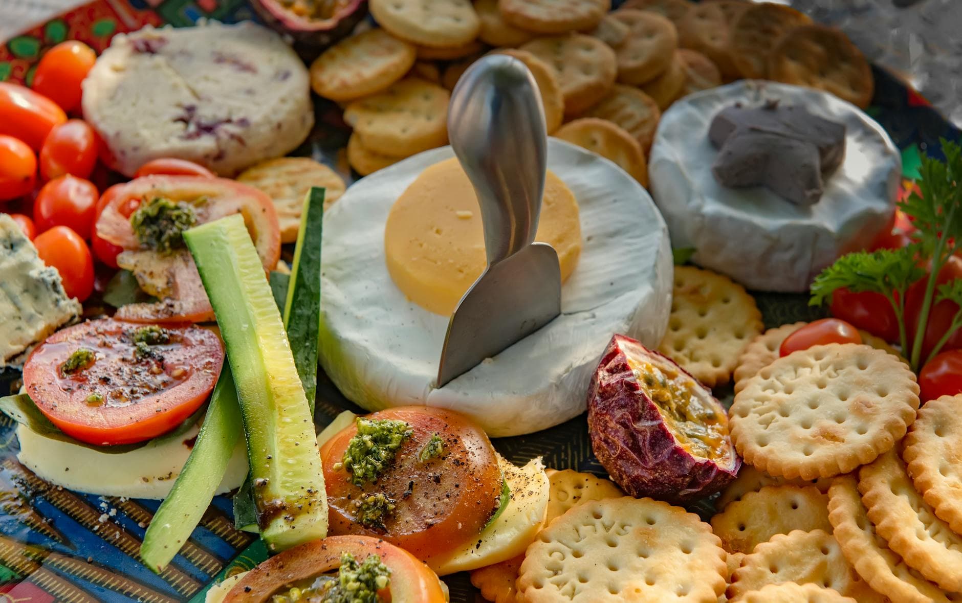 Delightful cheese platter with fresh vegetables and crackers, perfect for appetizers.